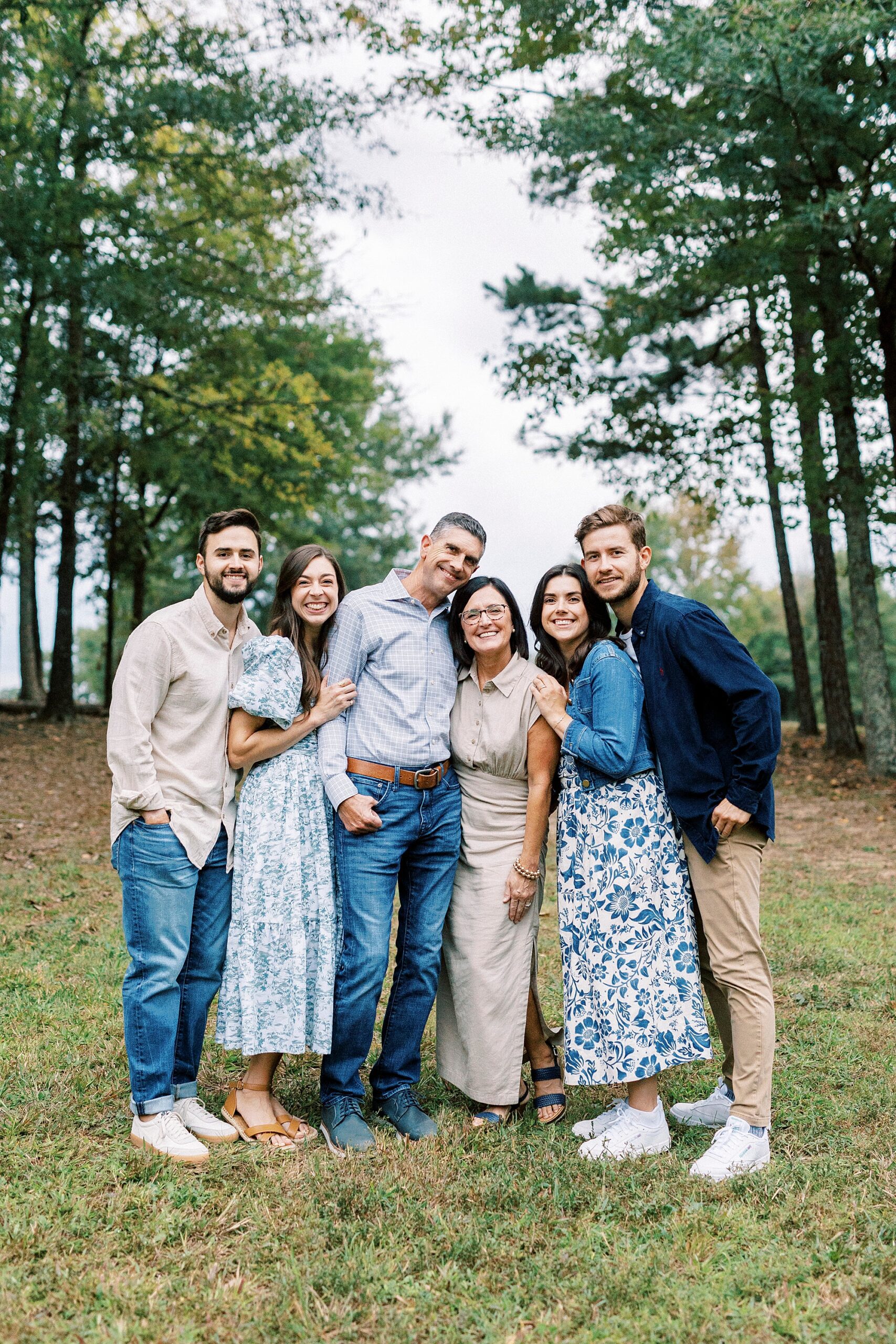 family of six hugs between trees at Rob Wallace Park
