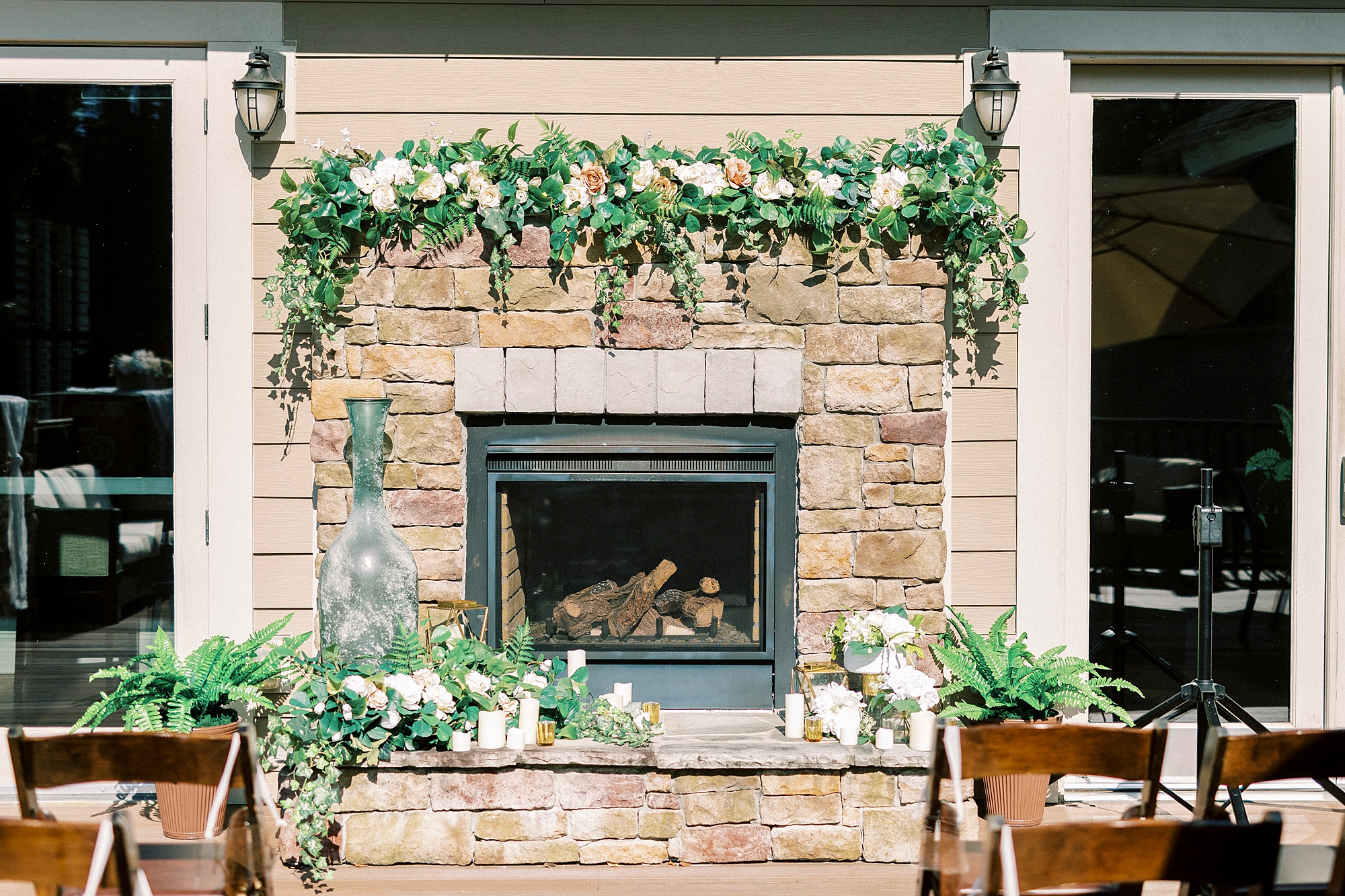 stone fireplace with white and green flowers on the mantle 
