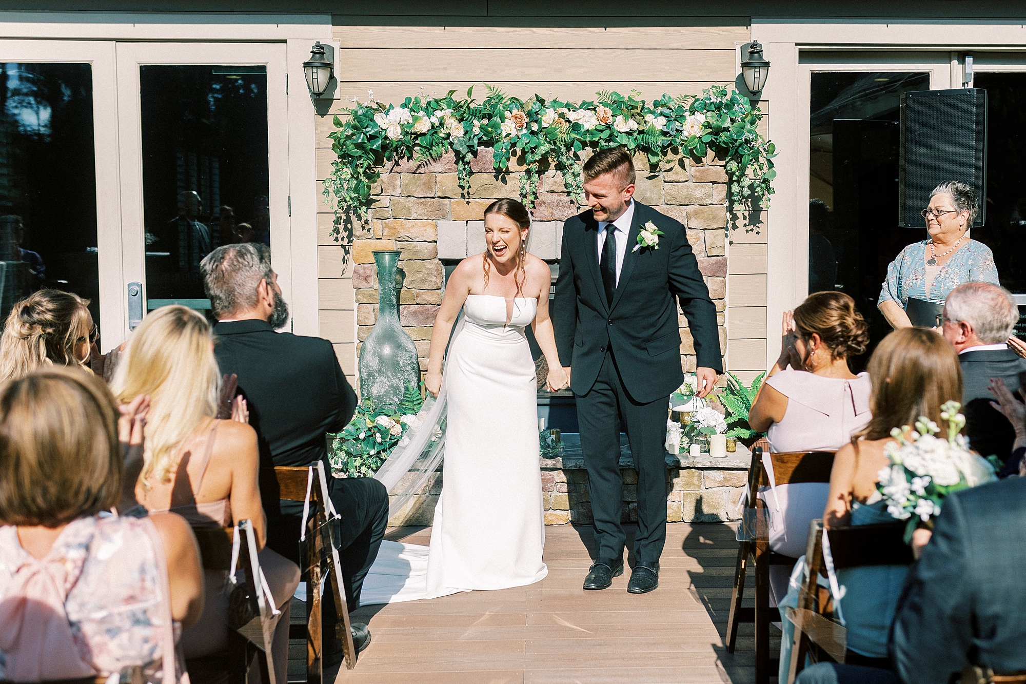 bride and groom smile laughing walking up the aisle