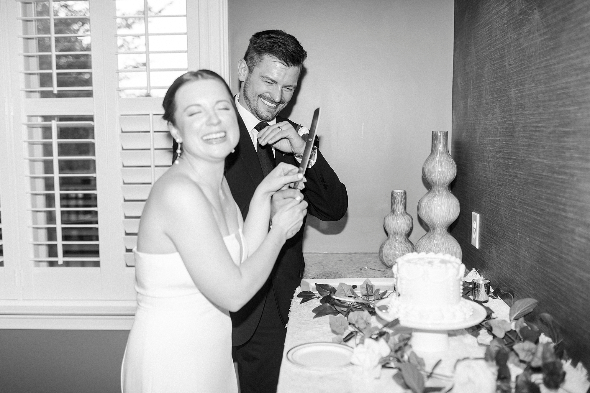 newlyweds laugh during cake cutting at wedding reception at Palisades Country Club