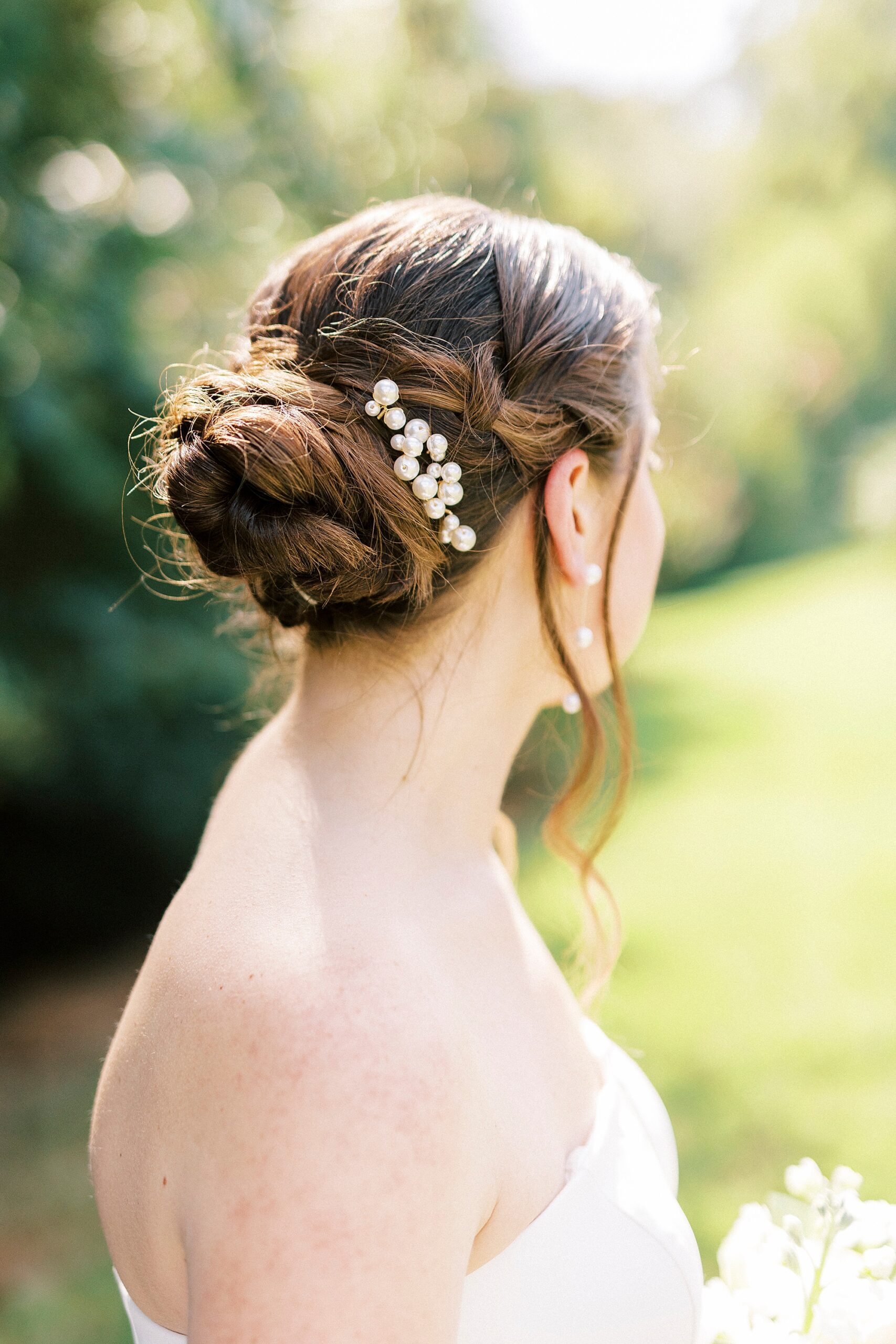 bride shows off bun and pearl accents