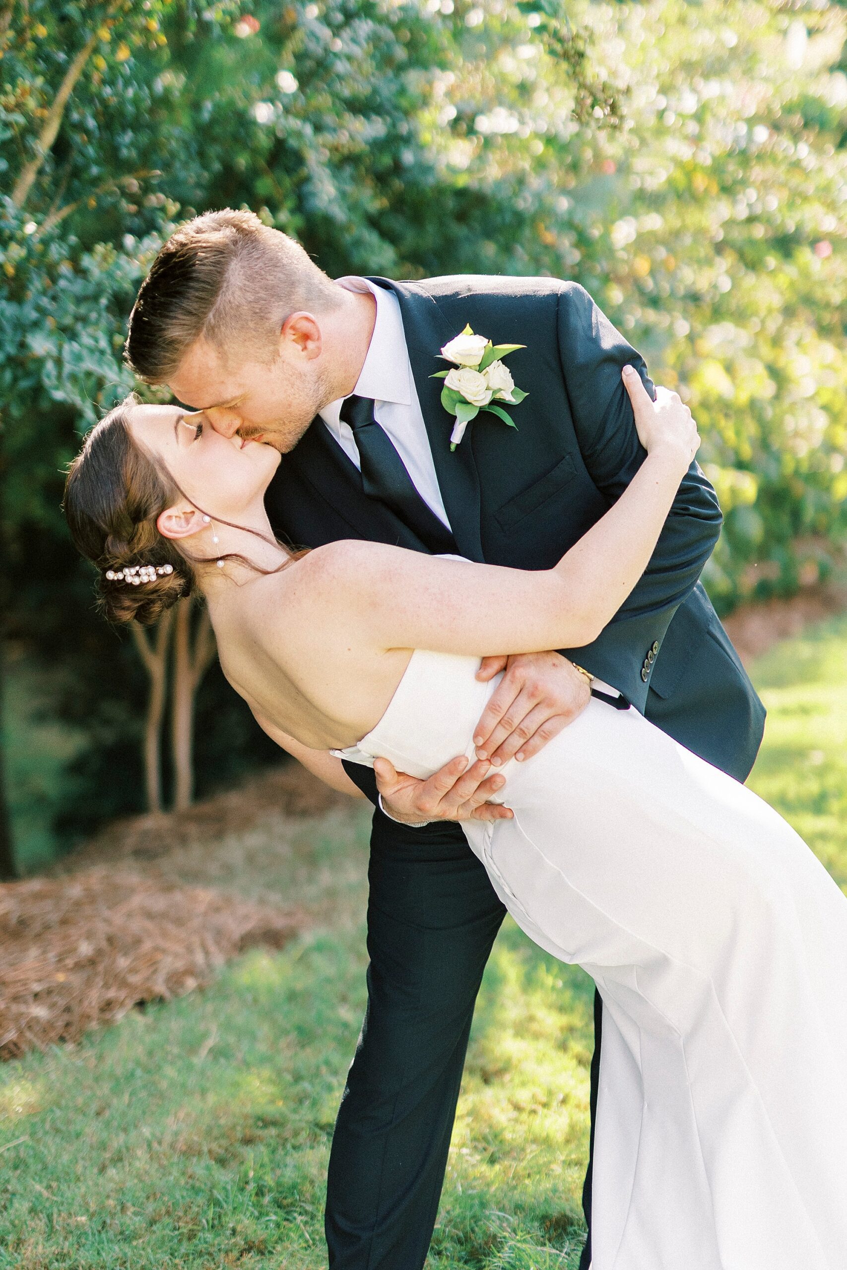 groom kisses bride dipping her during wedding day at the Palisades