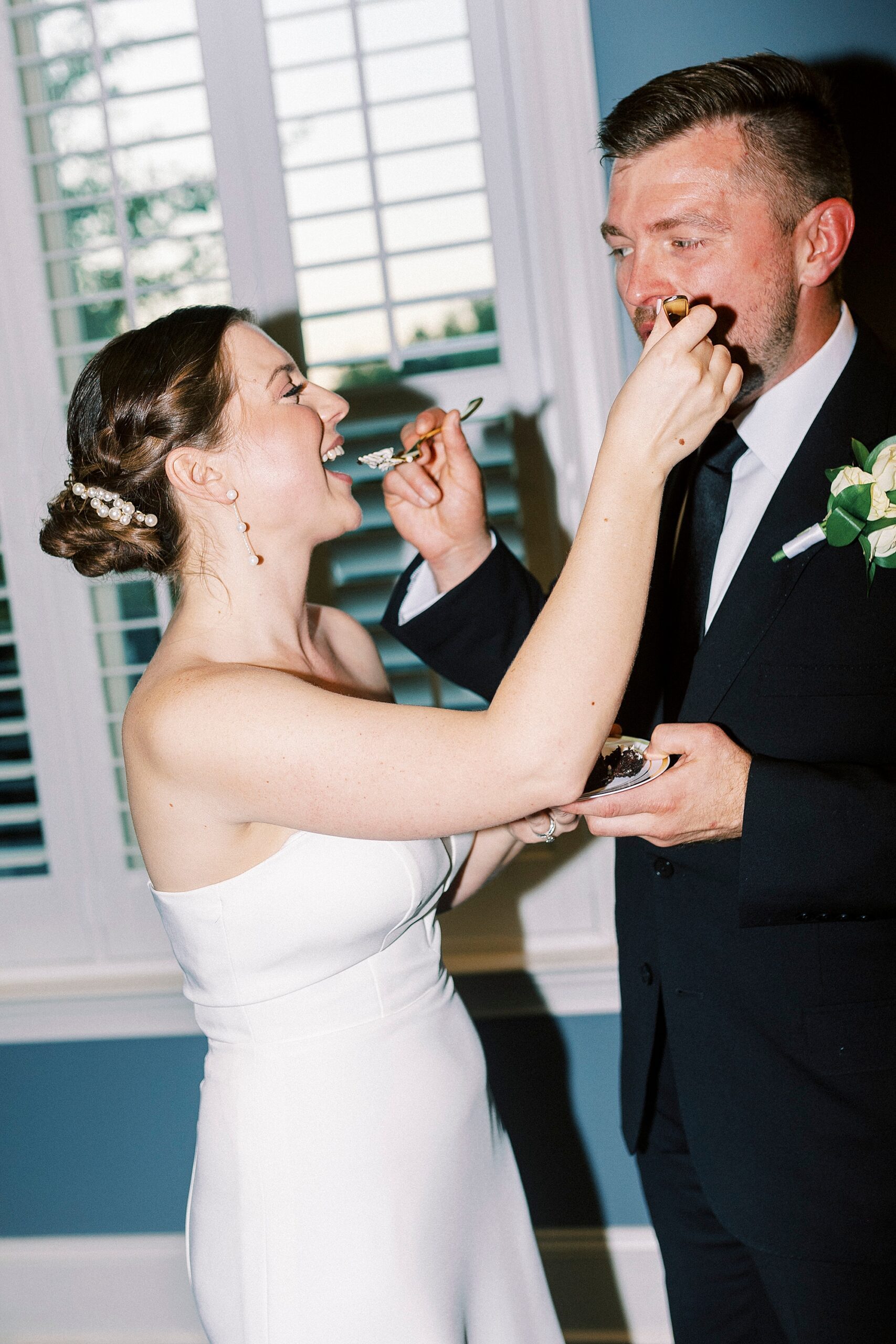 bride and groom feed each other cake during wedding reception at Palisades Country Club