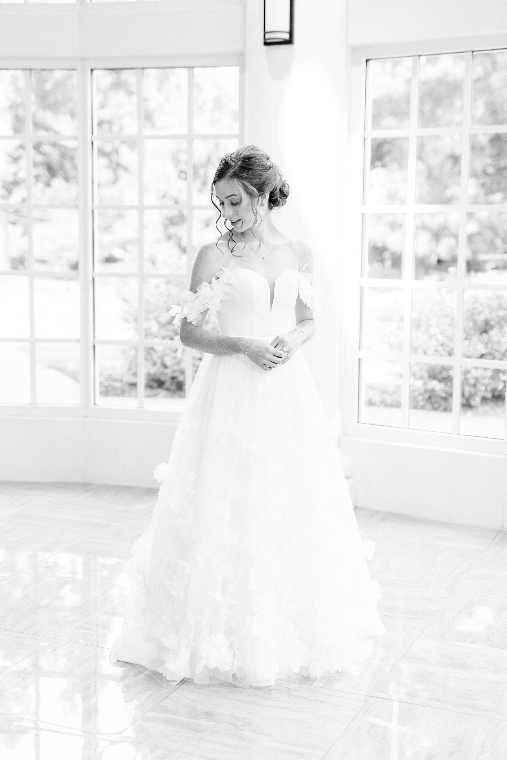 bride poses in strapless wedding gown in the atrium of the Belk Chapel