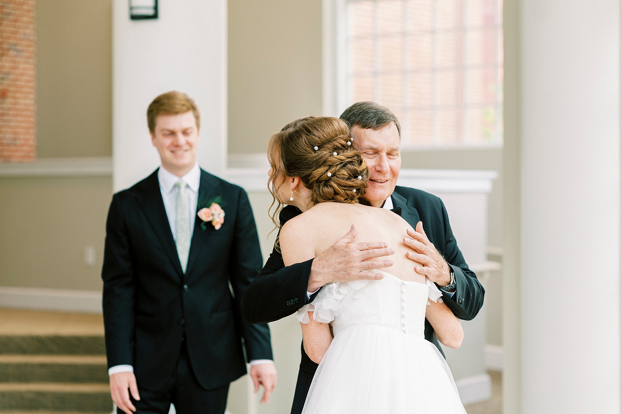 dad hugs daughter during first look inside the atrium of the Belk Chapel