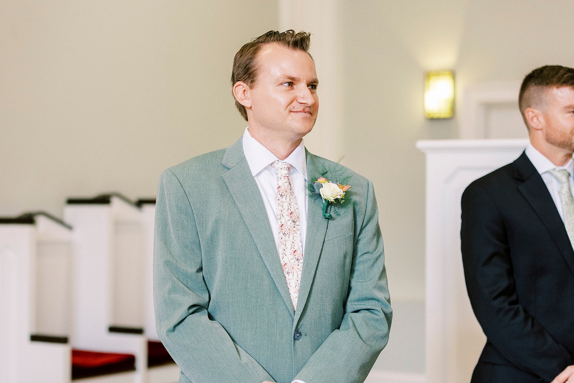 groom smiles watching aisle inside chapel in Charlotte NC