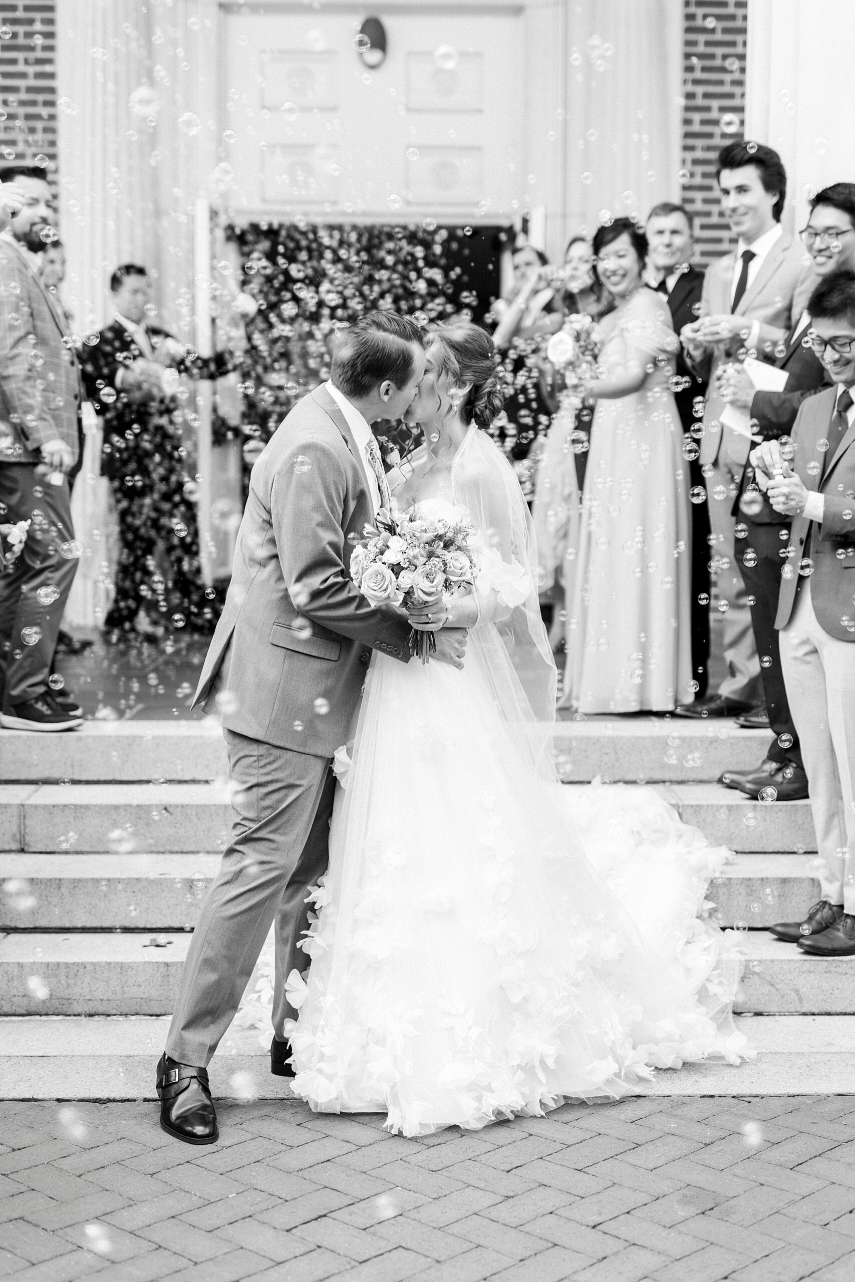 newlyweds kiss during bubble exit outside Belk Chapel