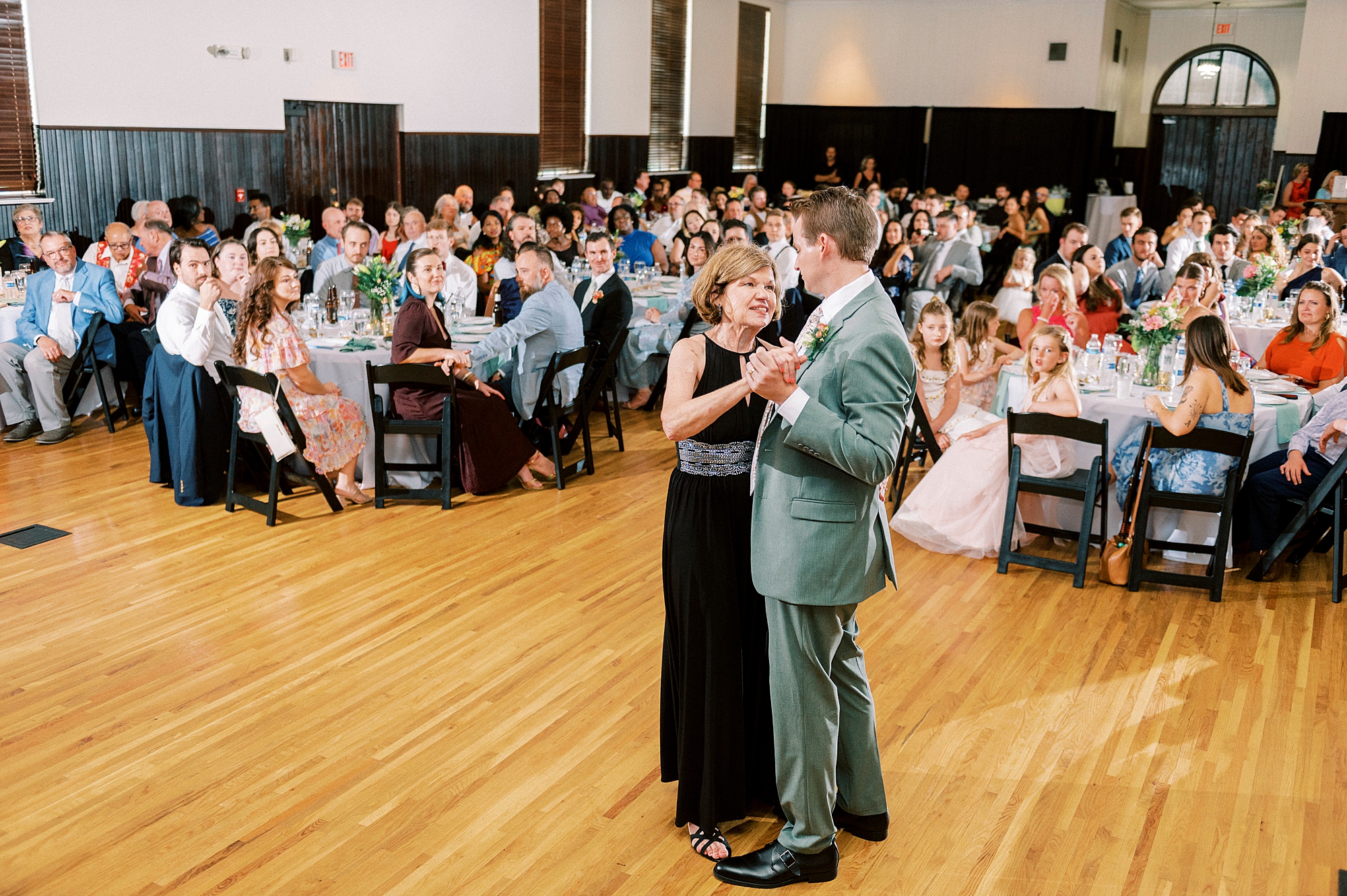 groom dances with mother during wedding reception at the Palmer Building