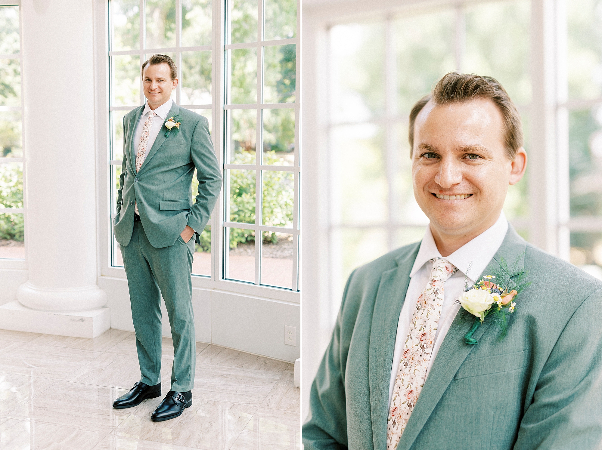 groom stands in blue suit with floral tie in atrium at Belk Chapel