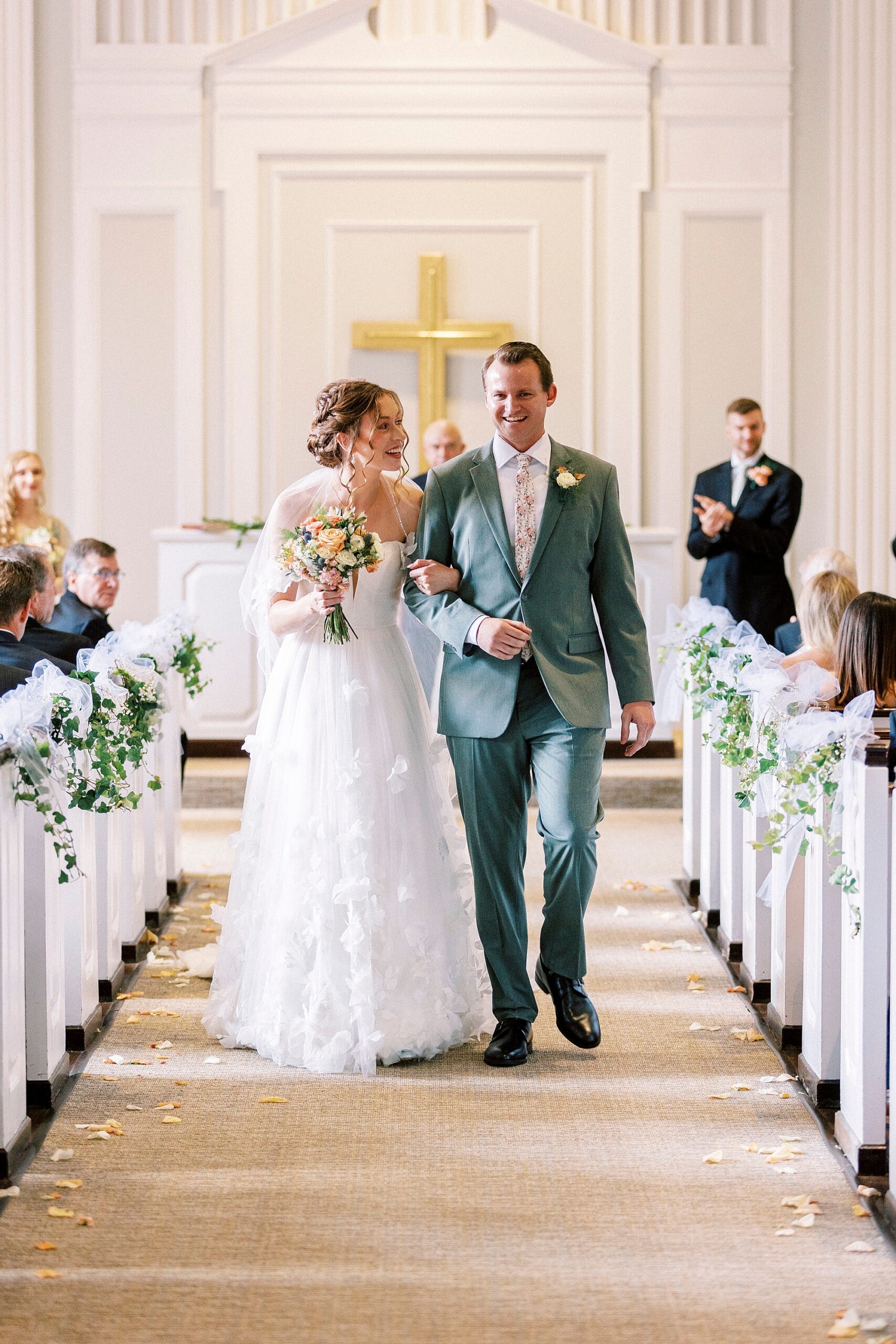 newlyweds walk up aisle at Belk Chapel