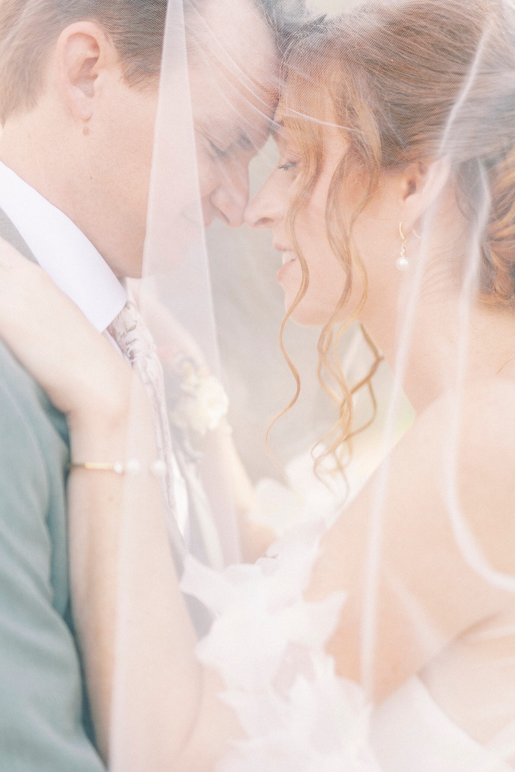 bride and groom hug under bride's veil