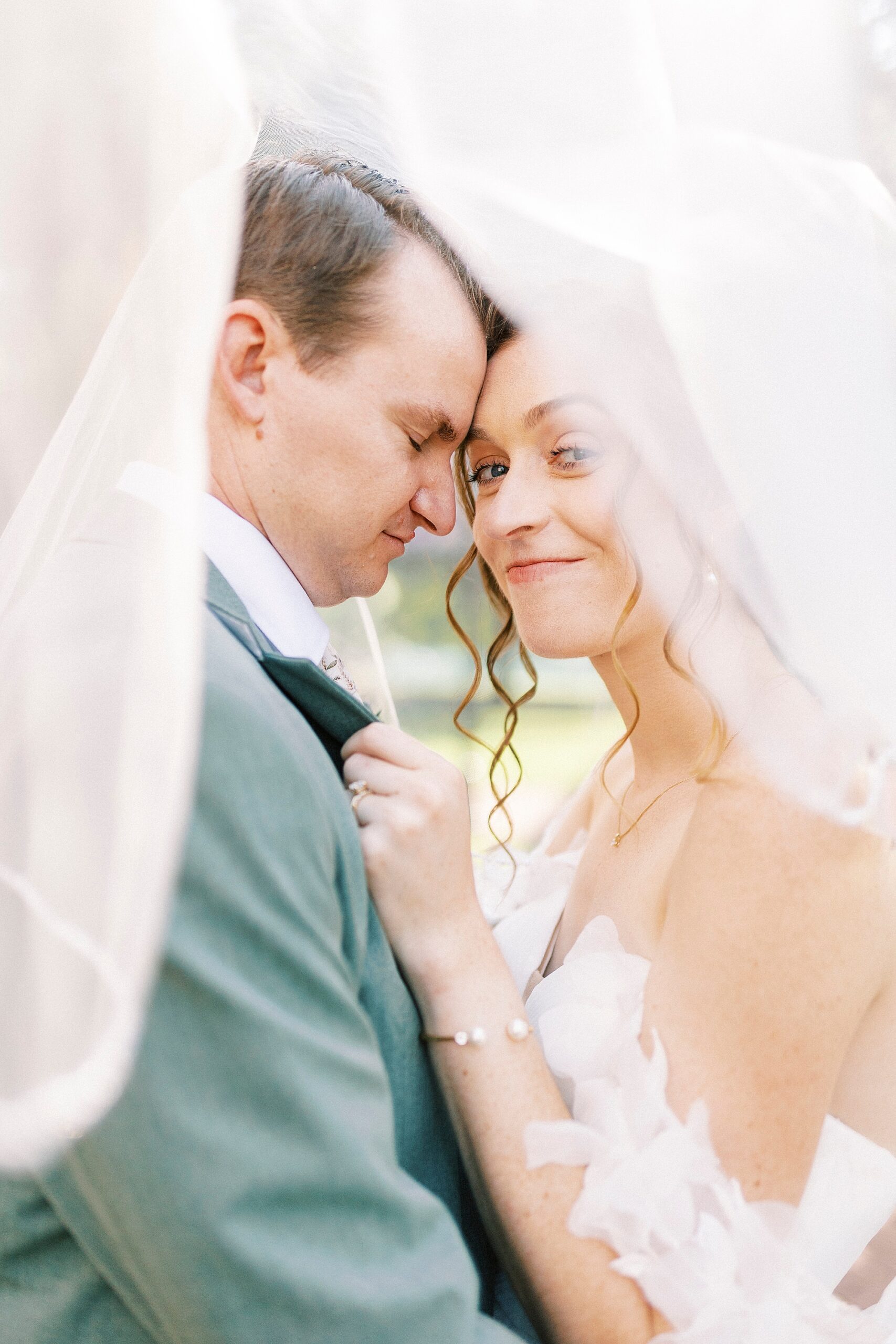 bride hugs groom under her veil