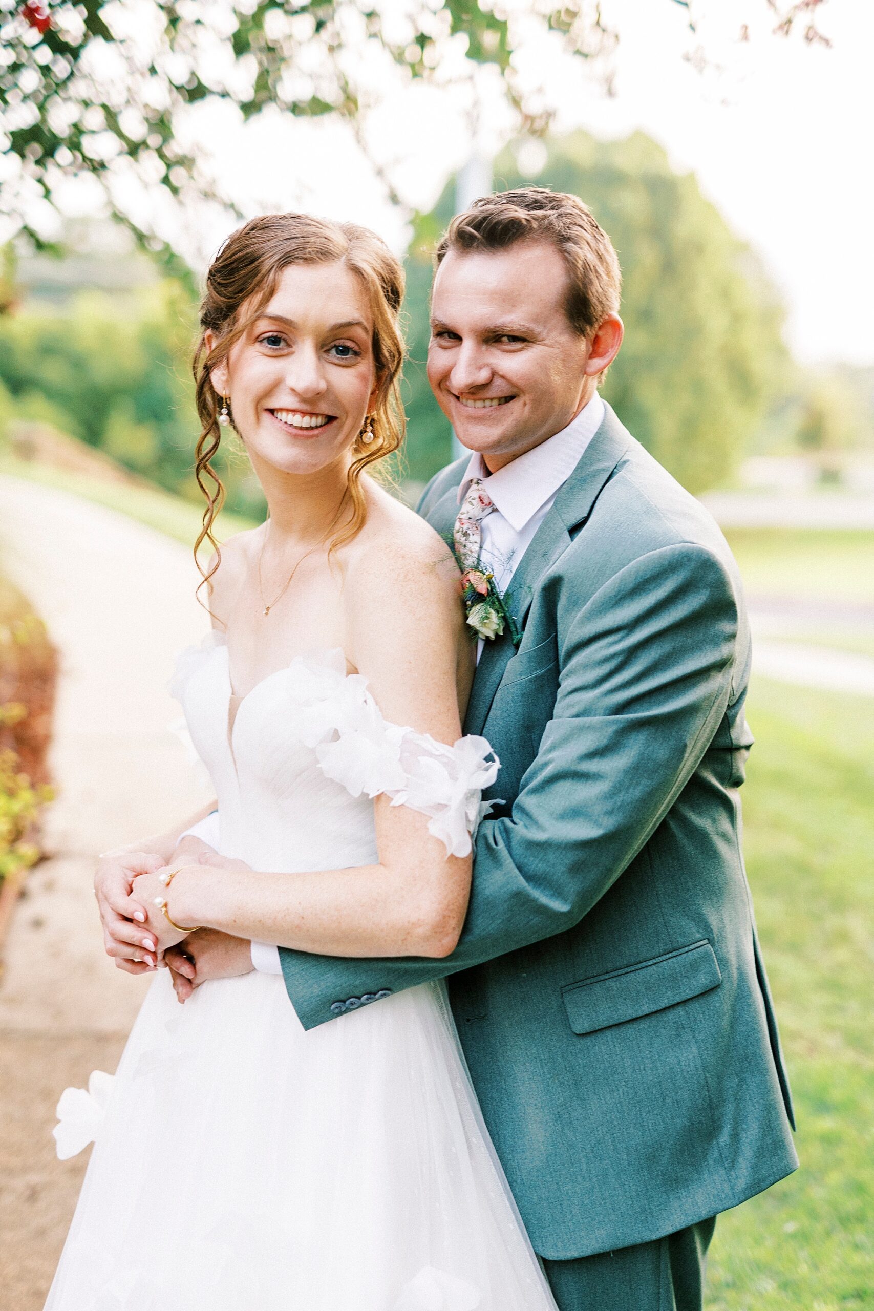 groom hugs bride around waist during Charlotte wedding day