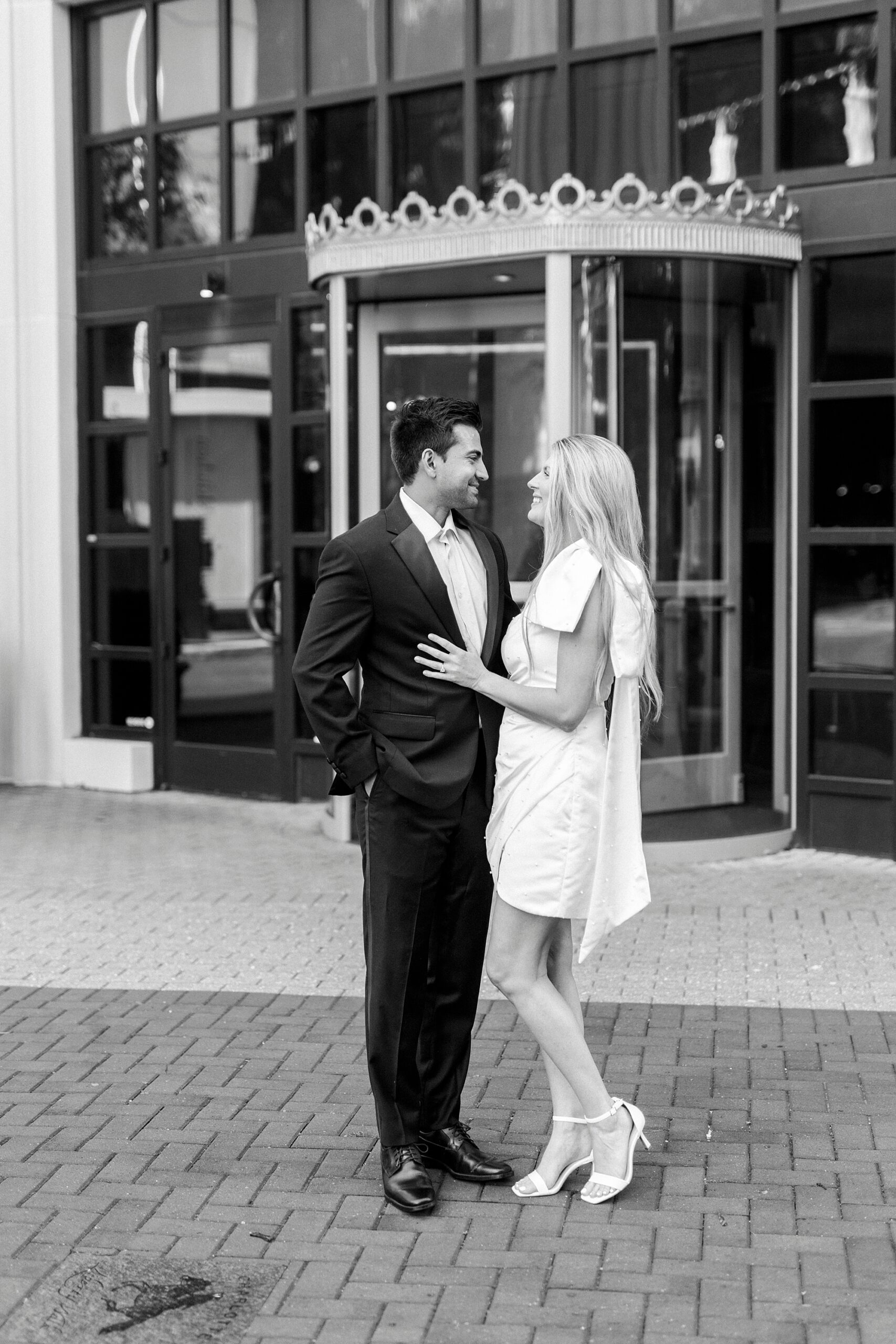 woman in chic white dress hugs man in suit outside the Grand Bohemian Hotel in Charlotte NC