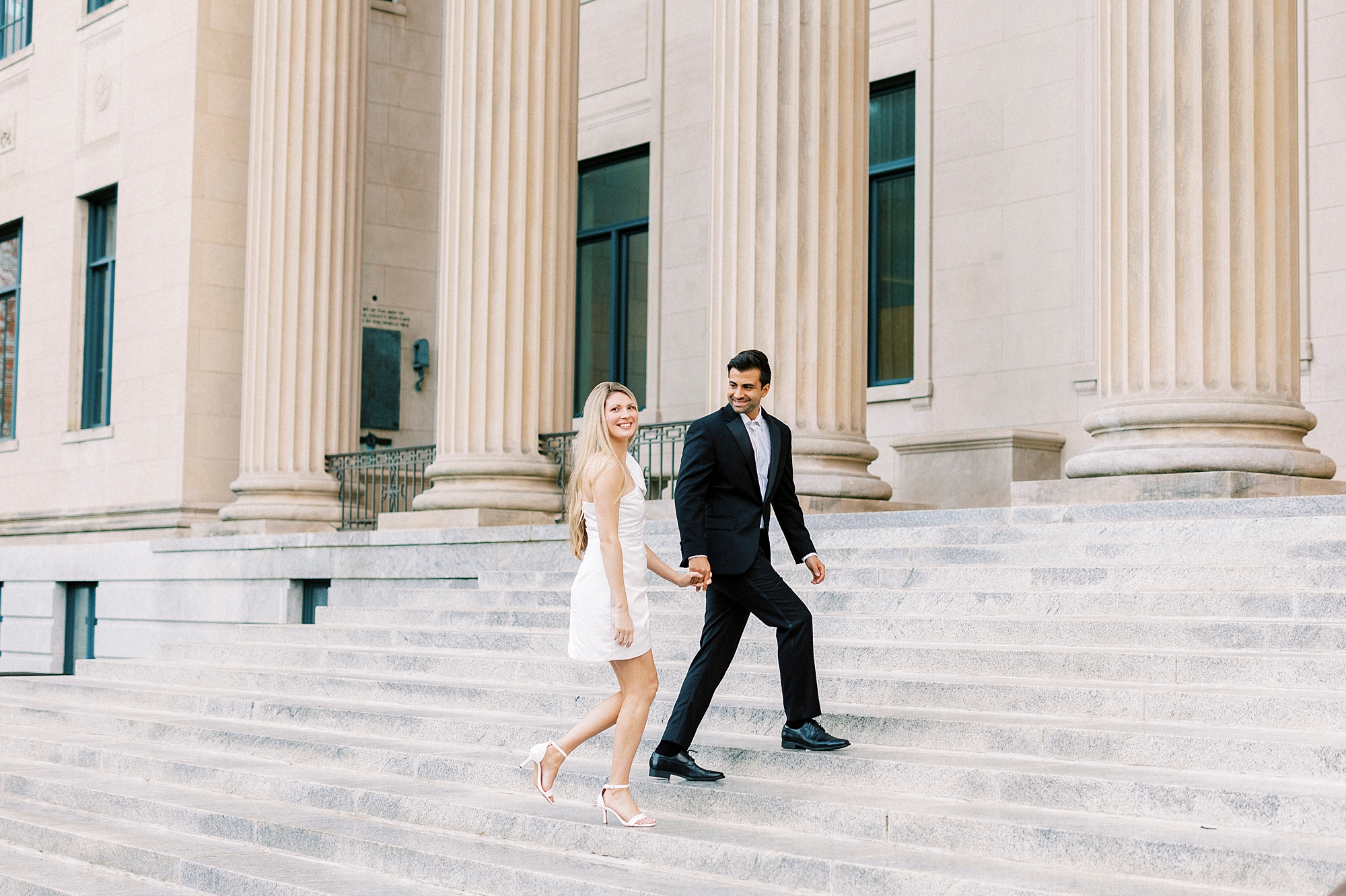 man leads woman up steps of Charlotte NC building with columns 