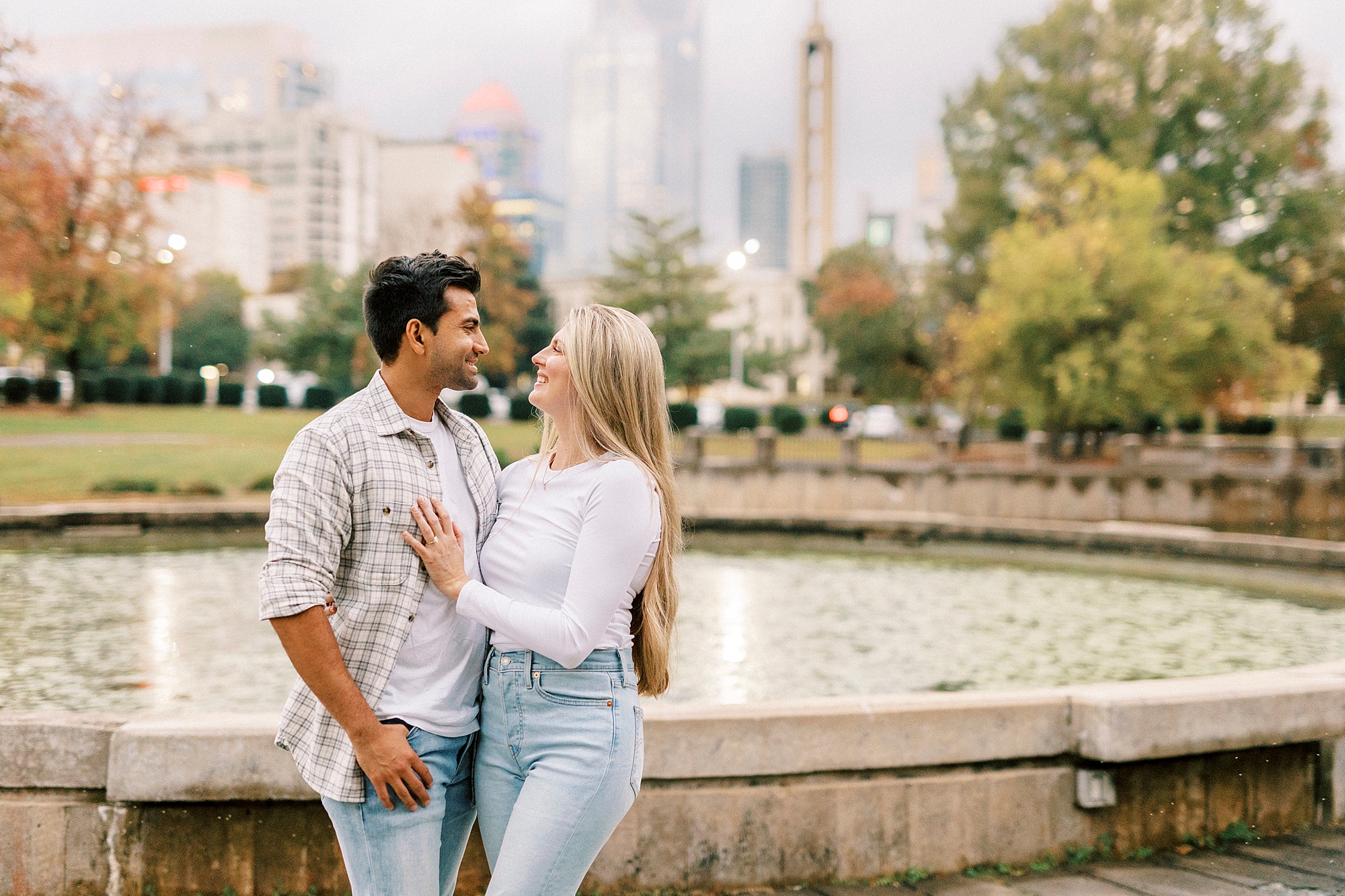 engaged couple hug by fountain in Marshall Park