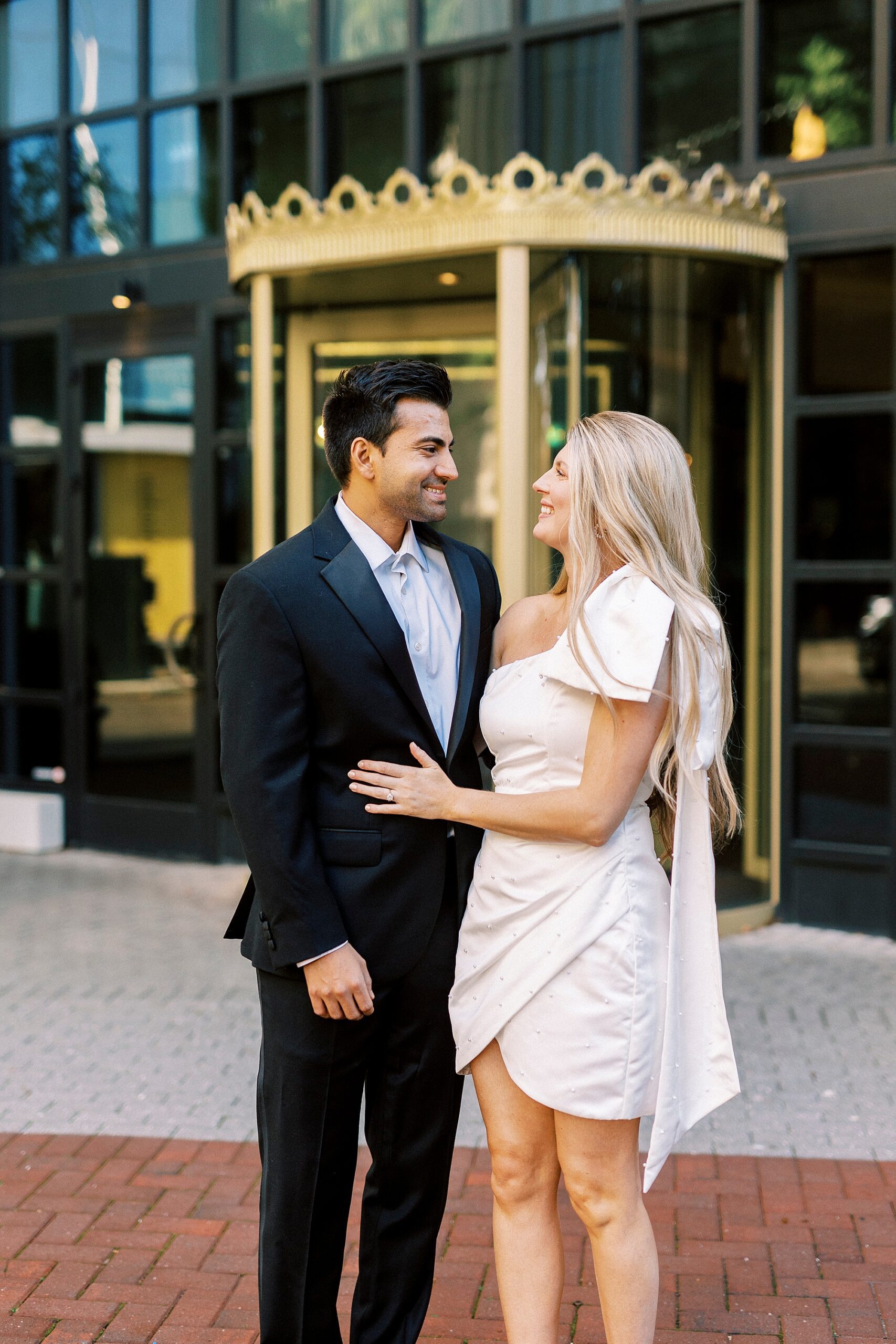 engaged couple smiles laughing outside the Grand Bohemian Hotel in Charlotte NC