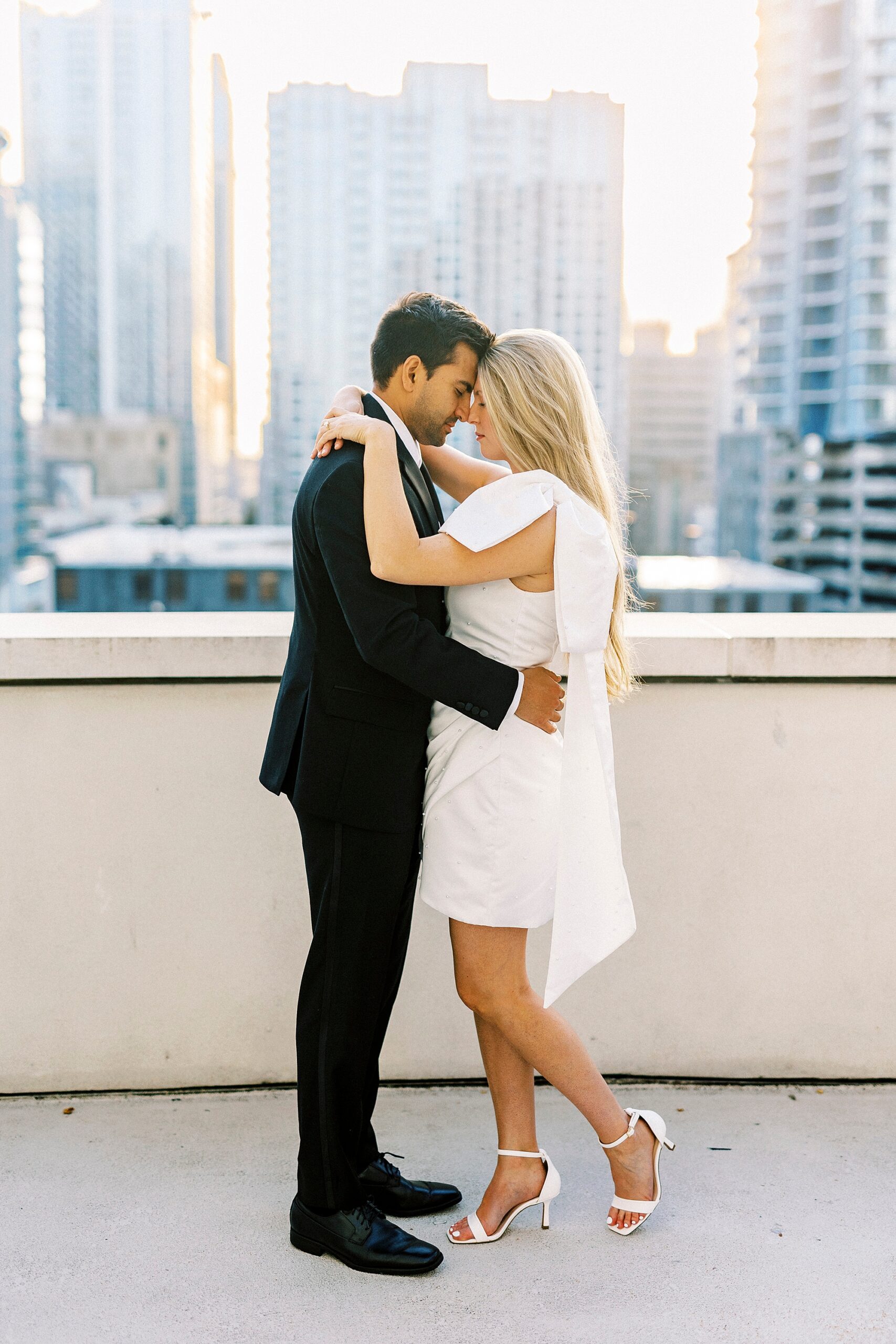 couple leans heads together on rooftop of hotel in Charlotte NC