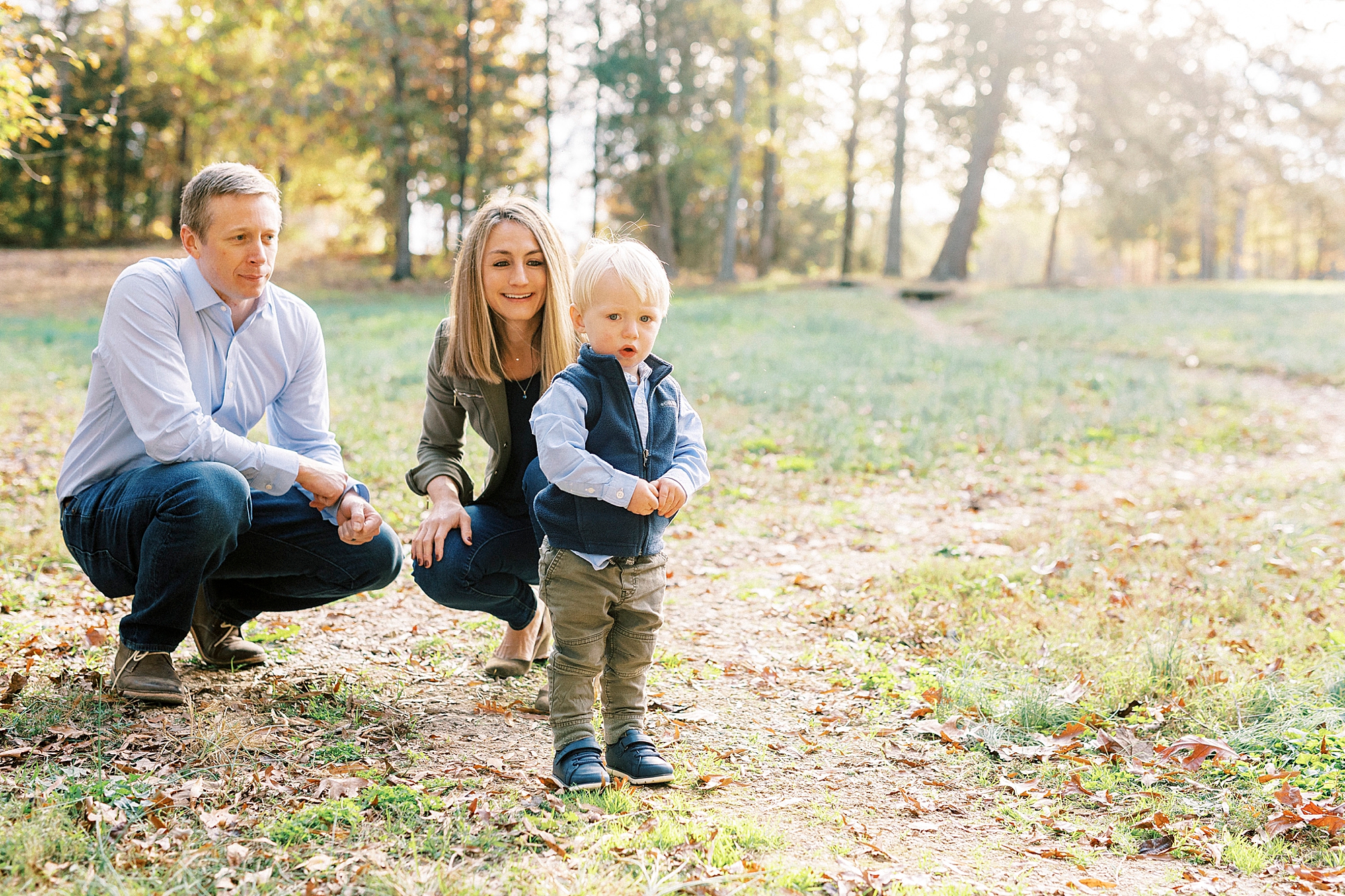 parents kneel with son during fall mini session at Rob Wallace Park