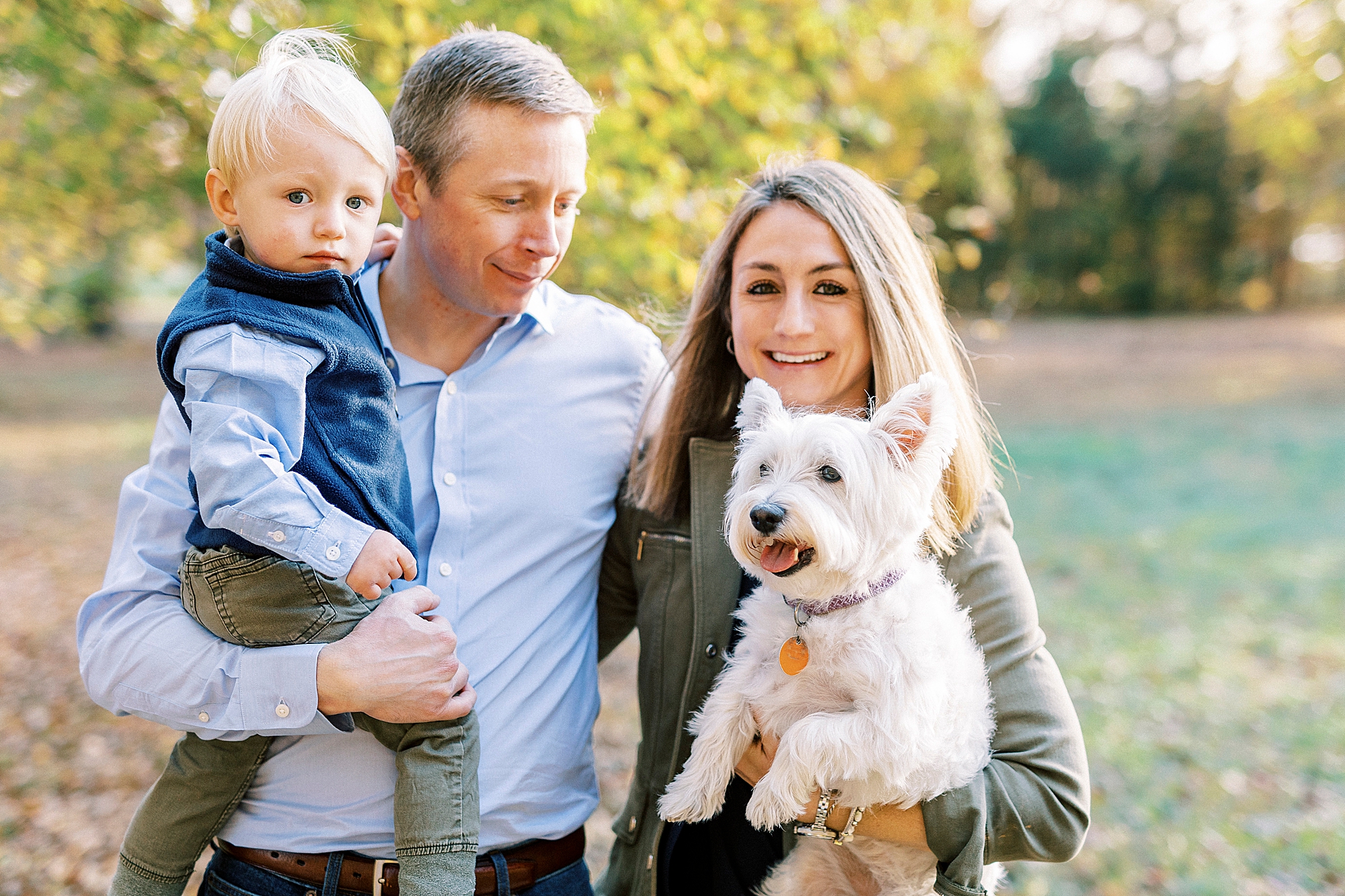 couple poses with son and dog during fall mini session at Rob Wallace Park