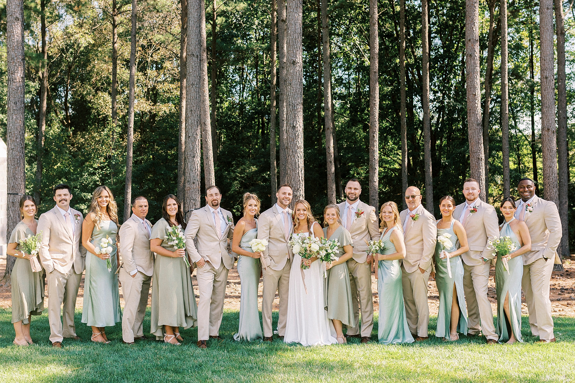 bride and groom stand with wedding party in mint and tan outfits in backyard in Richfield NC