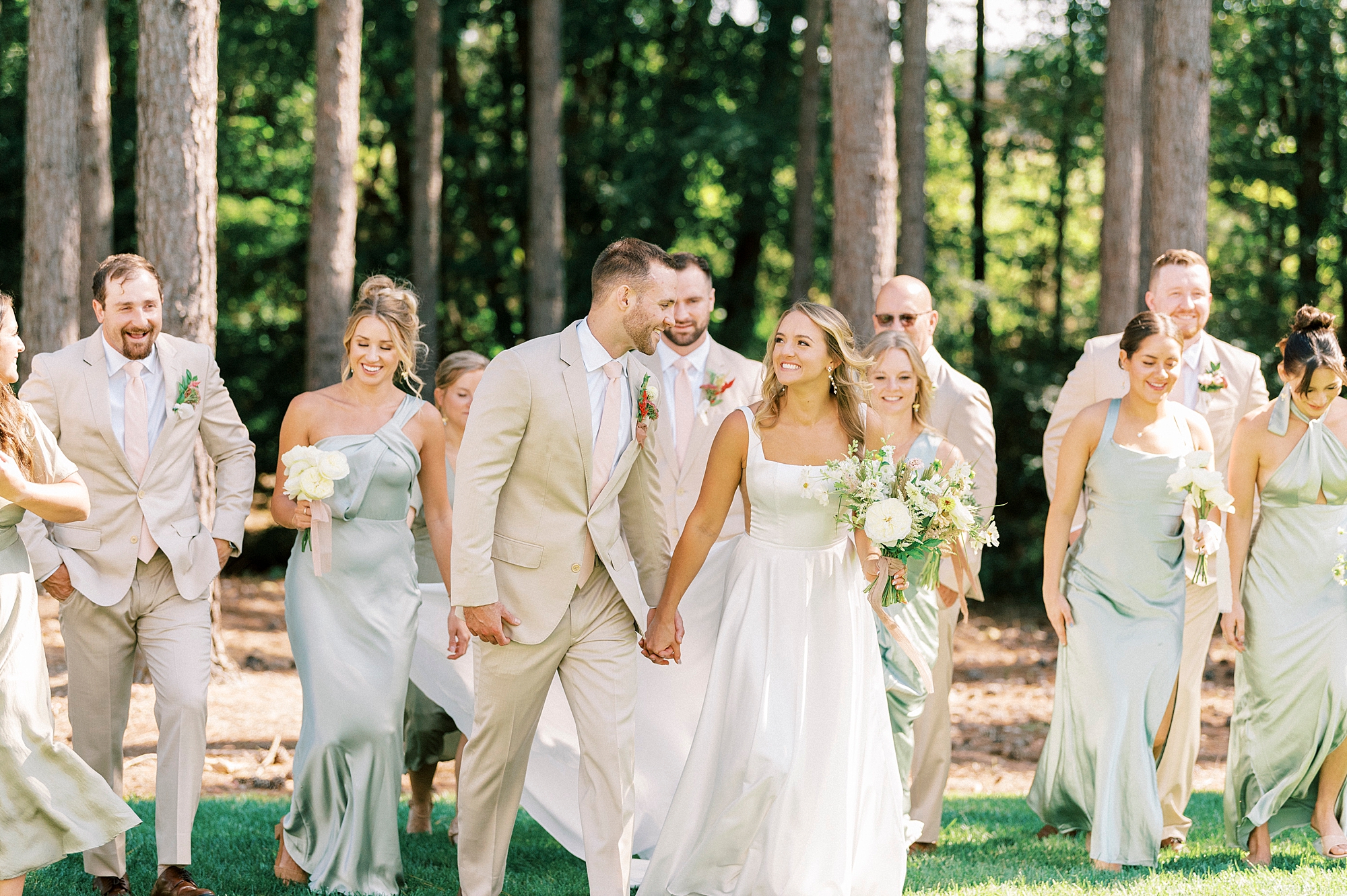 bride and groom walk in front of wedding party 