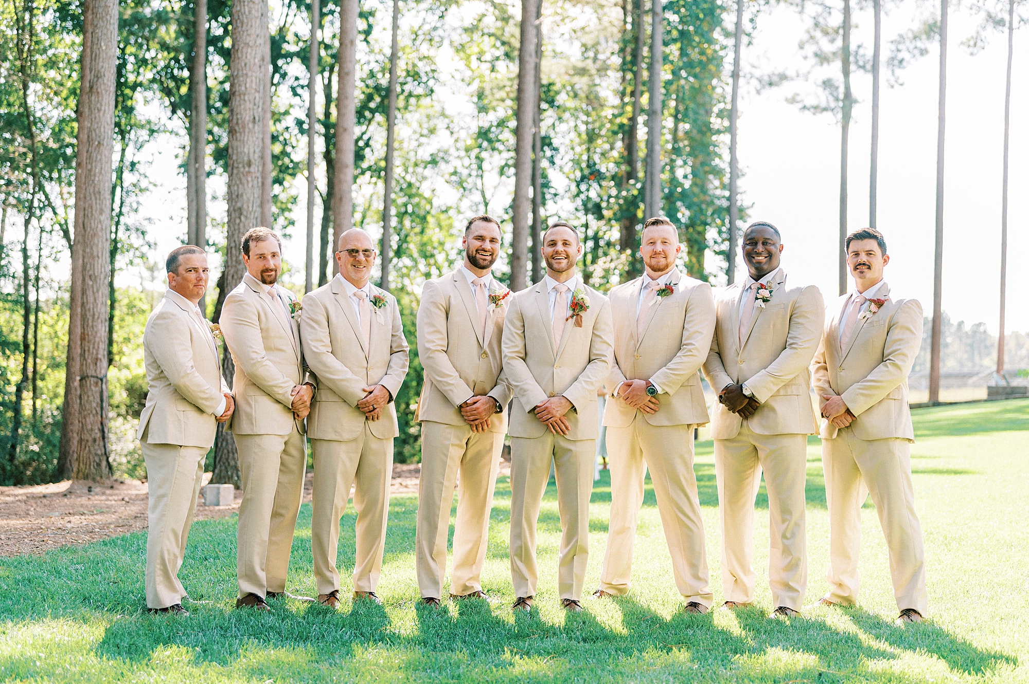 groom stands with groomsmen in tan suits in backyard at Richfield NC