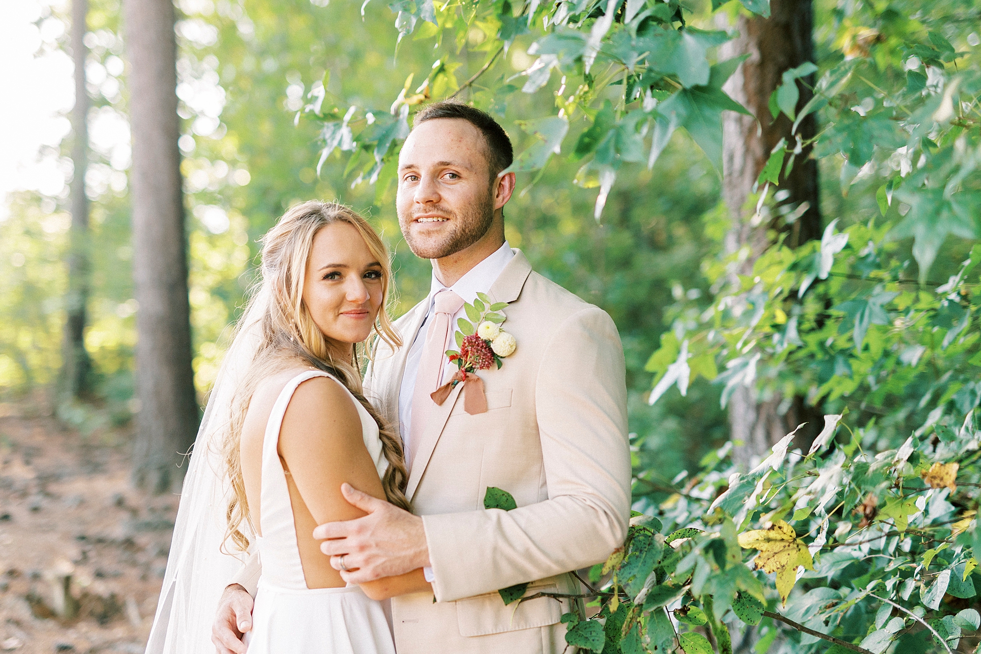bride and groom hug in woods of Richfield NC home
