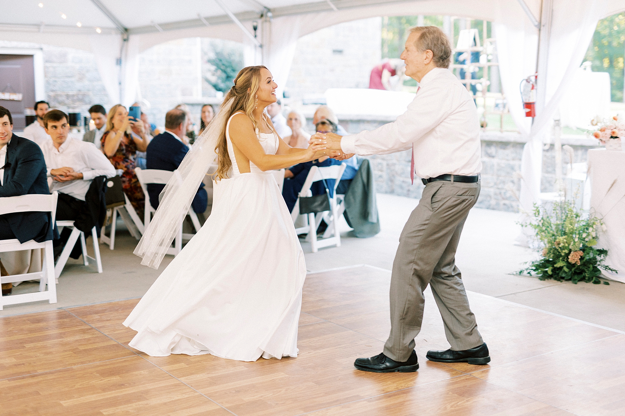 bride dances with father during reception under tent 