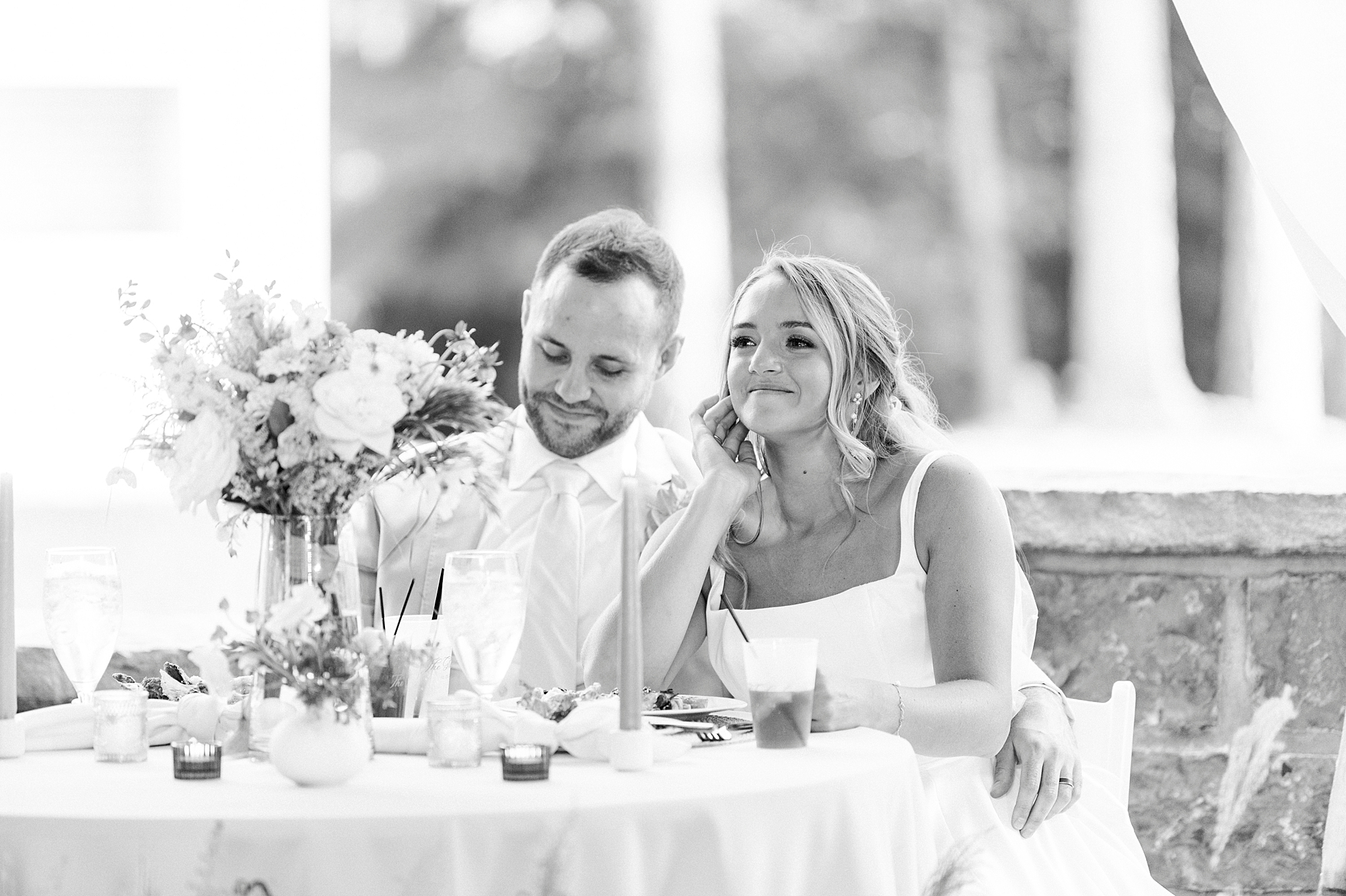 newlyweds smile hugging together under tent