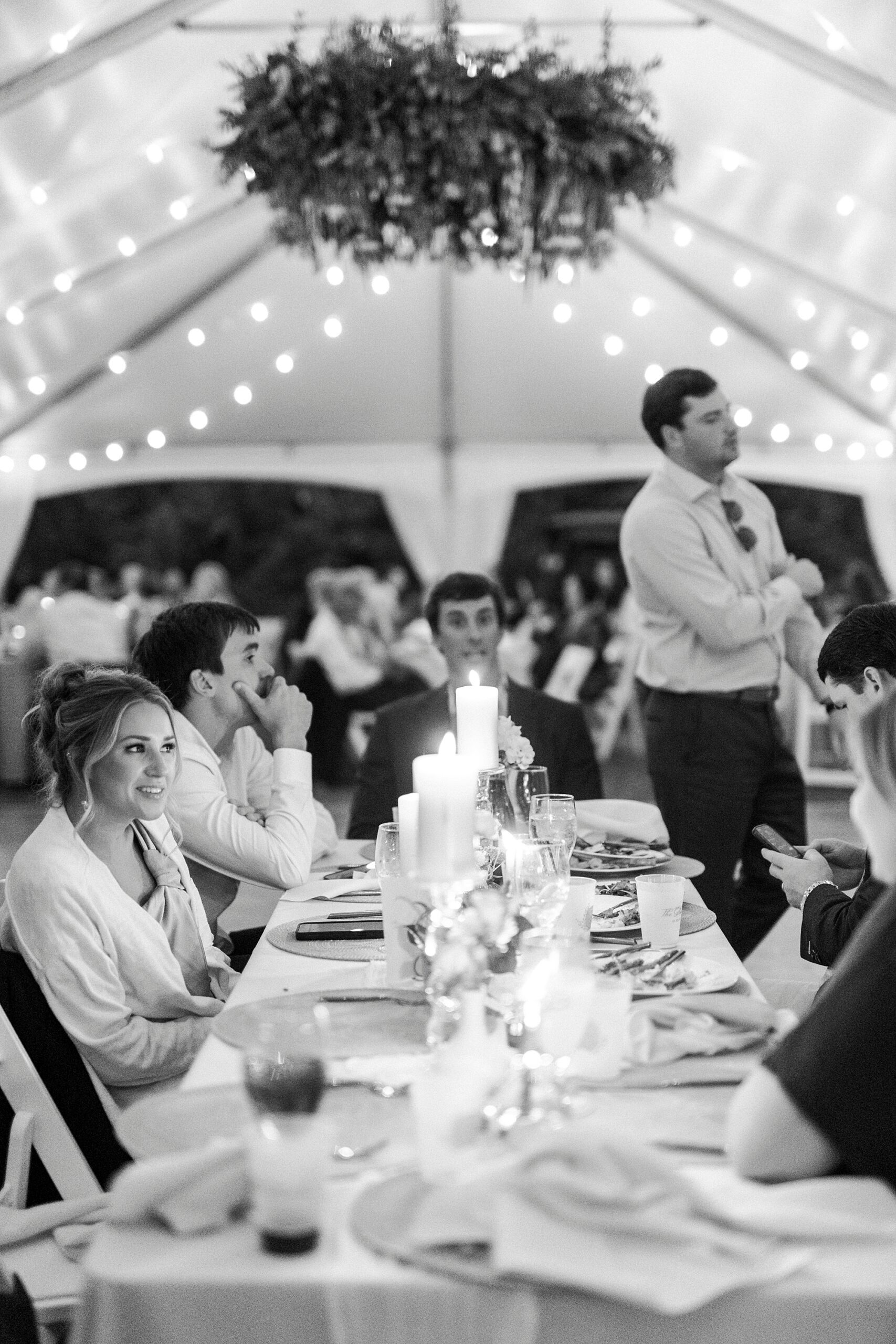 wedding guests sit at family style table for backyard wedding reception at Richfield NC home