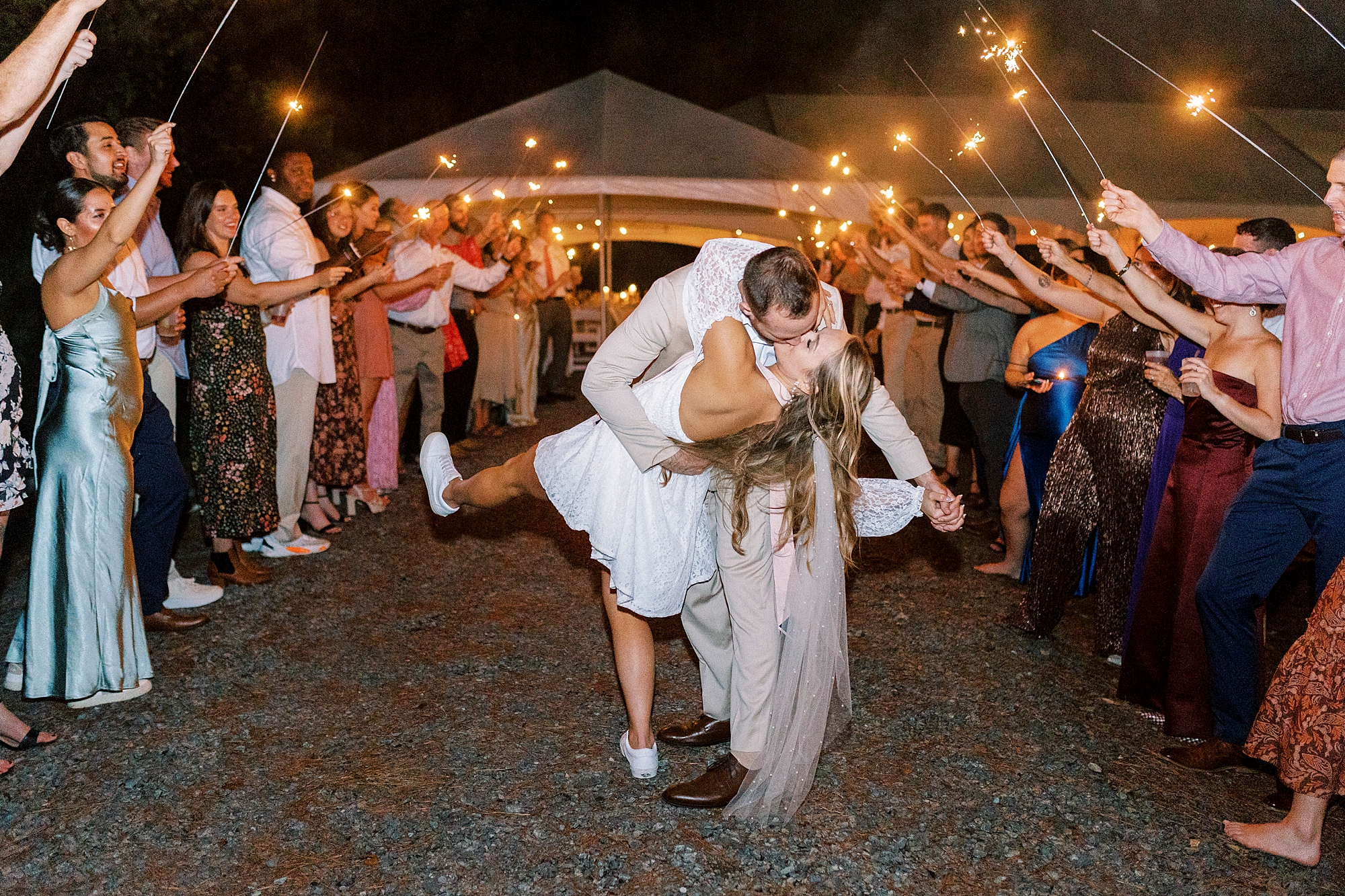 groom dips bride kissing her during sparkler exit 