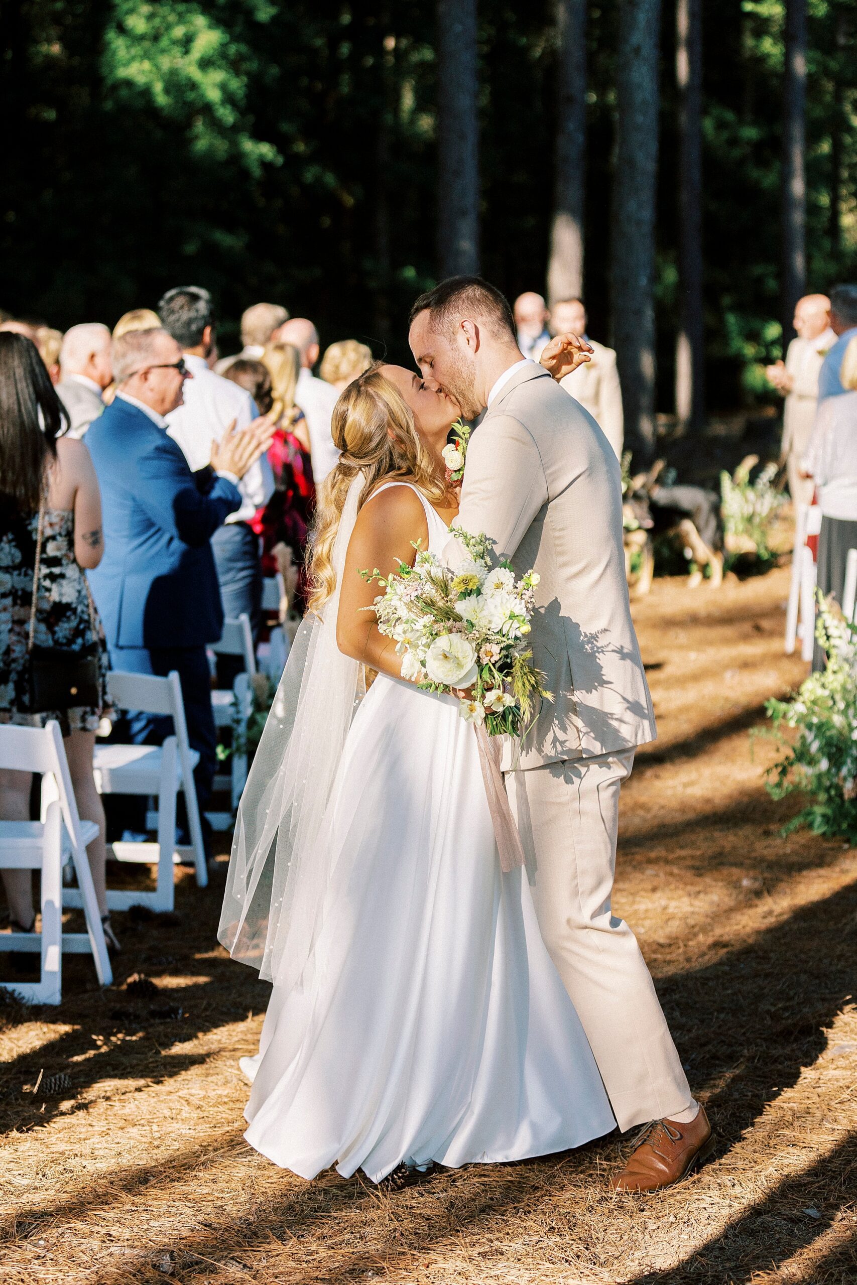 bride and groom kiss in aisle of wedding ceremony in backyard at Richfield NC home