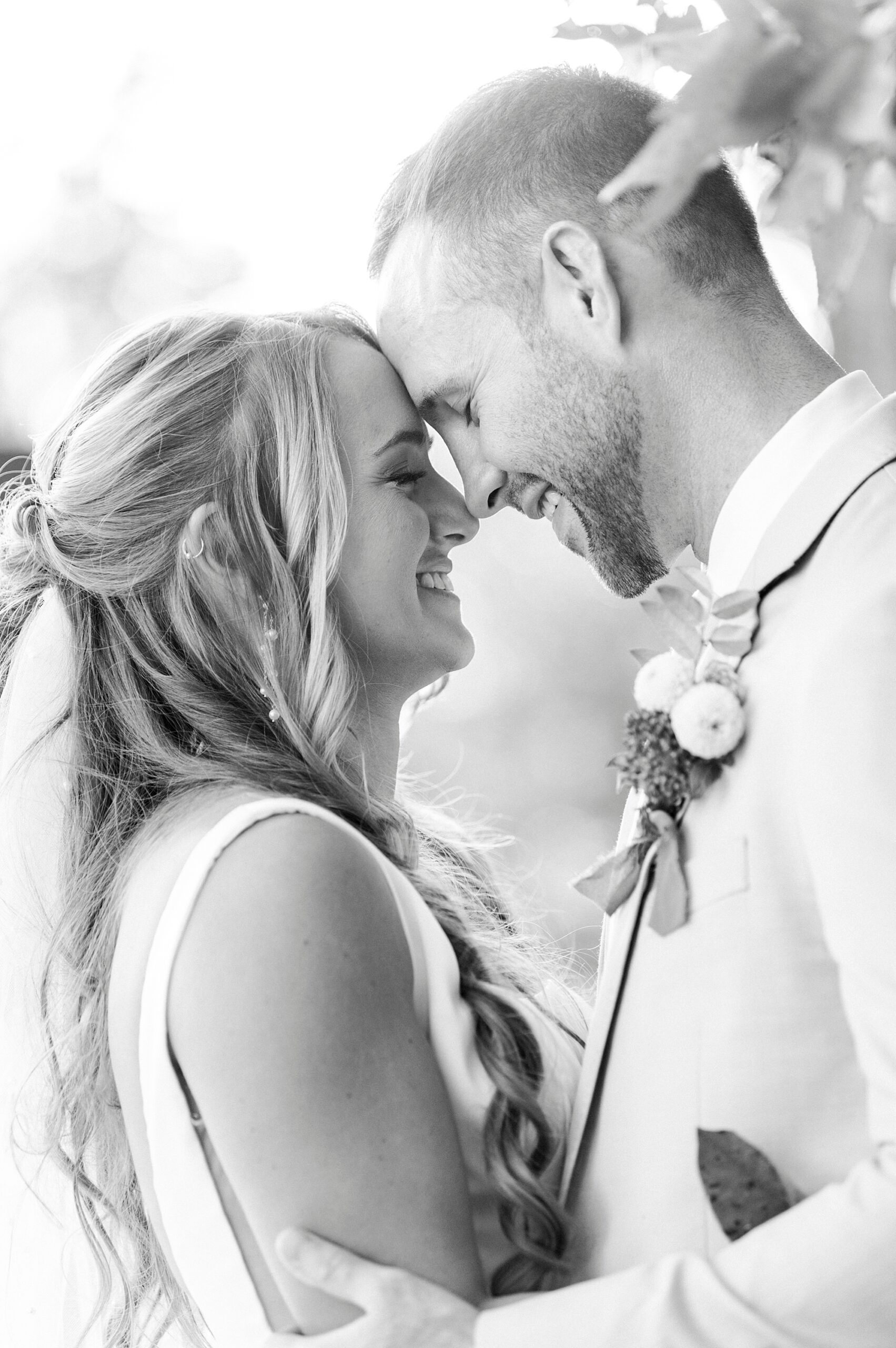 bride and groom lean heads together touching noses 