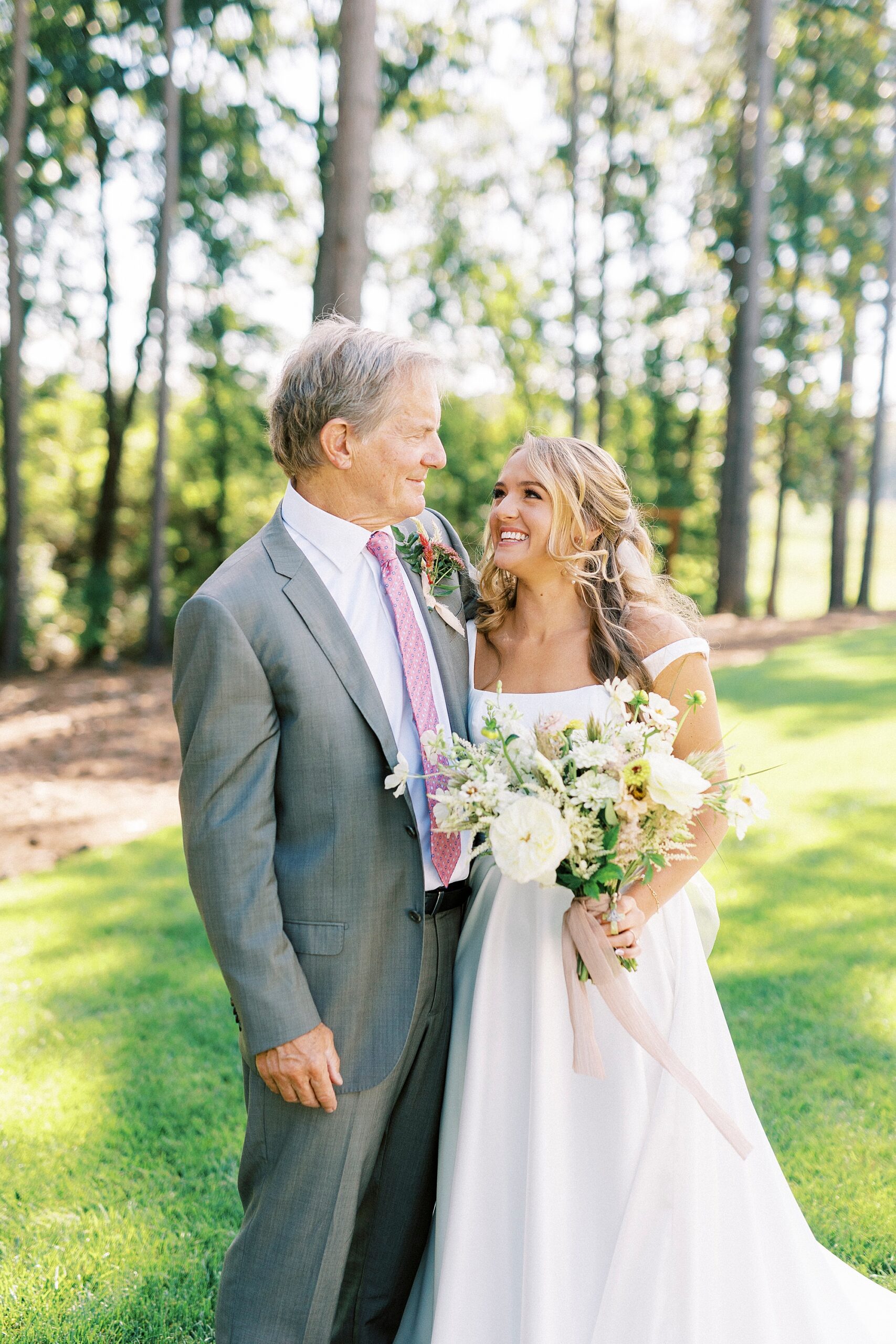 bride smiles up at dad during first look
