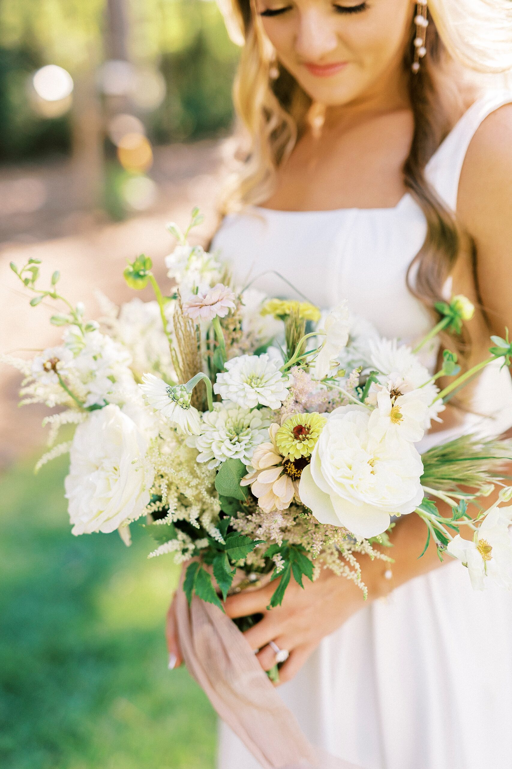 bride holds bouquet of white and green flowers