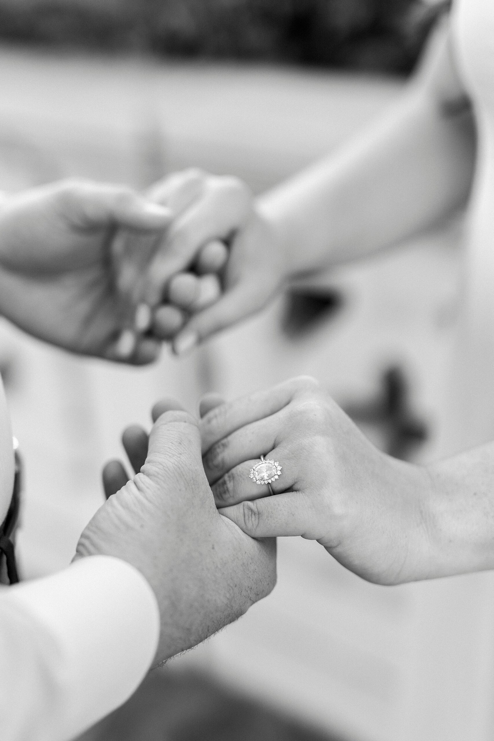 couple holds hands showing off woman's engagement ring