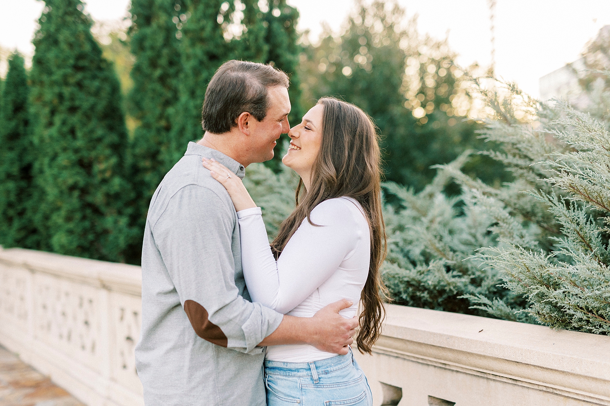 man and woman lean together touching noses on bridge inside Midtown Park