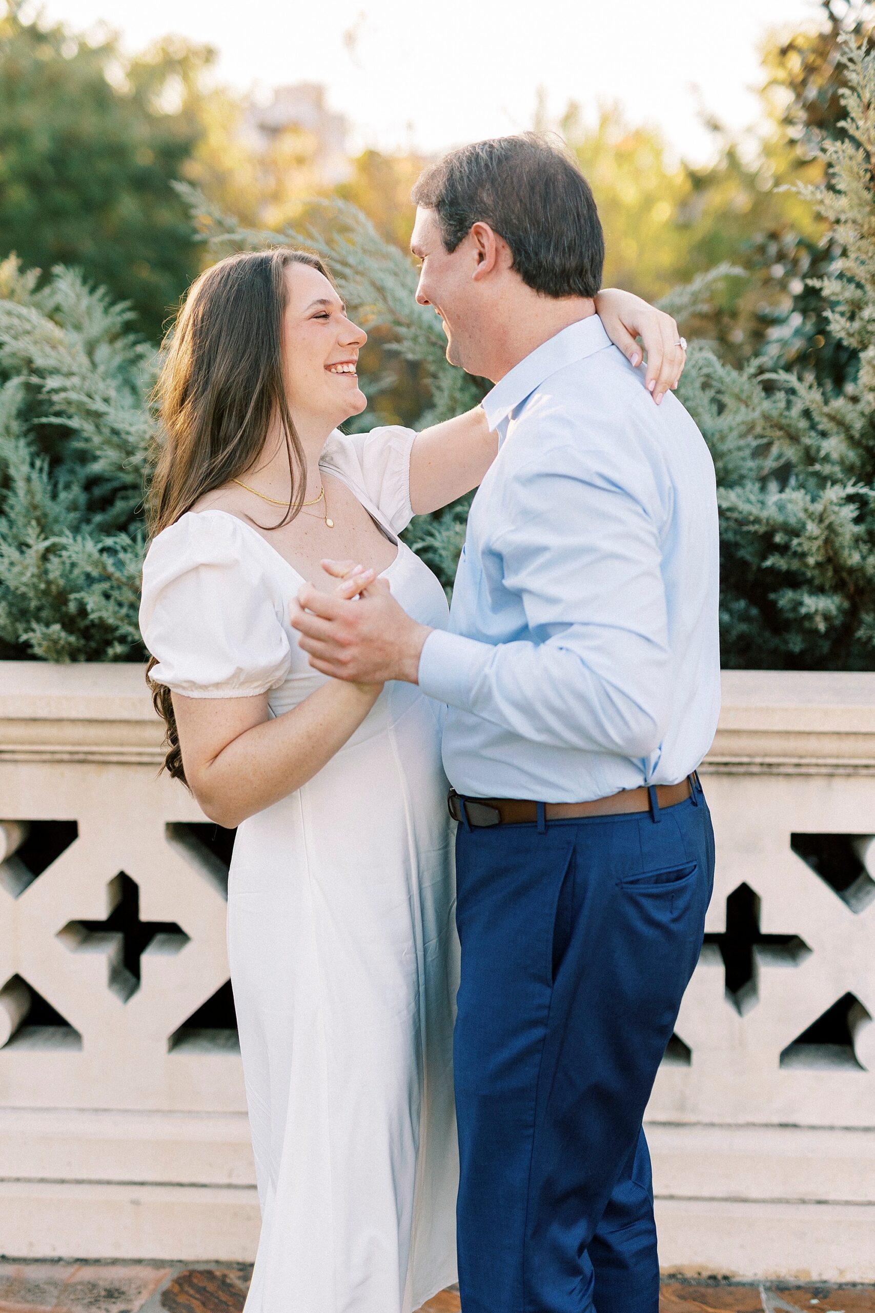 man and woman dance together in front of stone bridge 