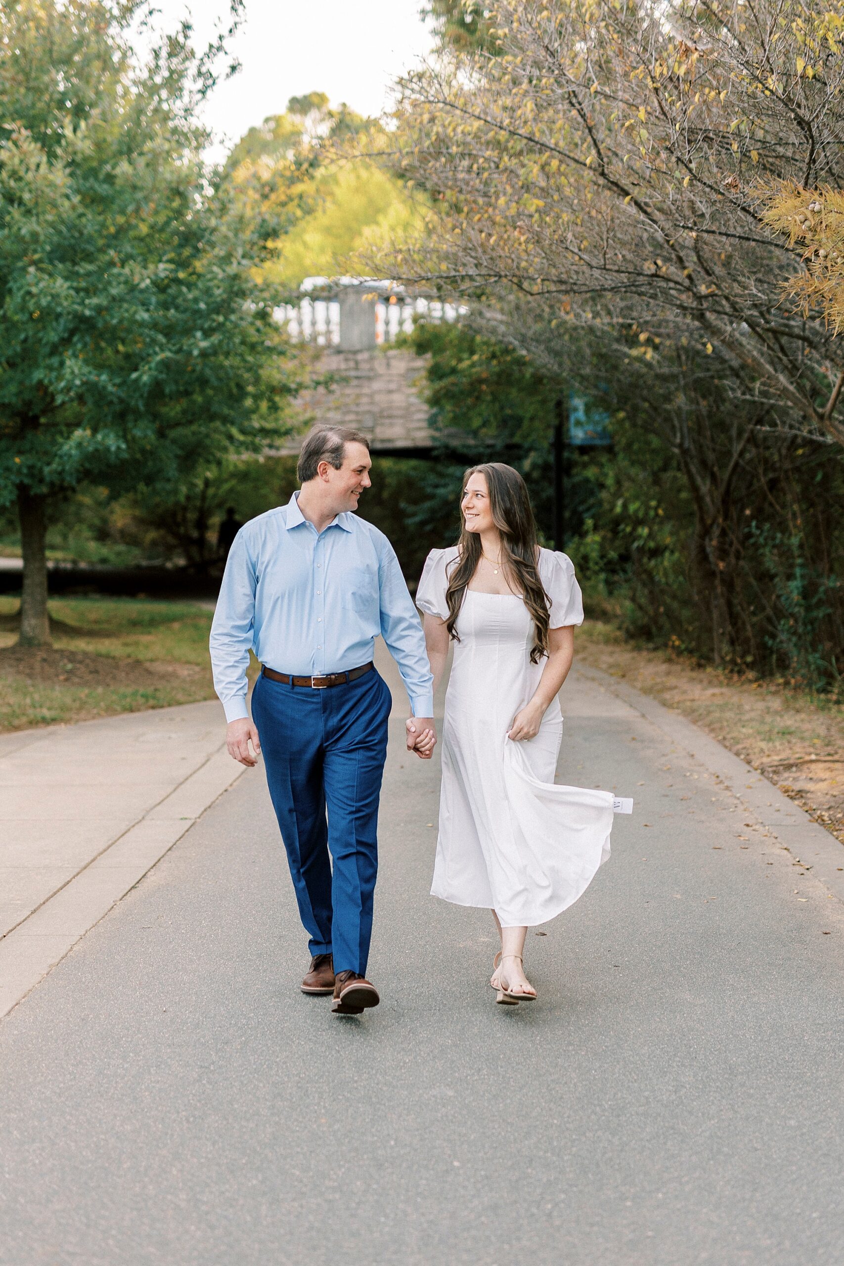 man and woman hold hands walking down path inside Midtown Park