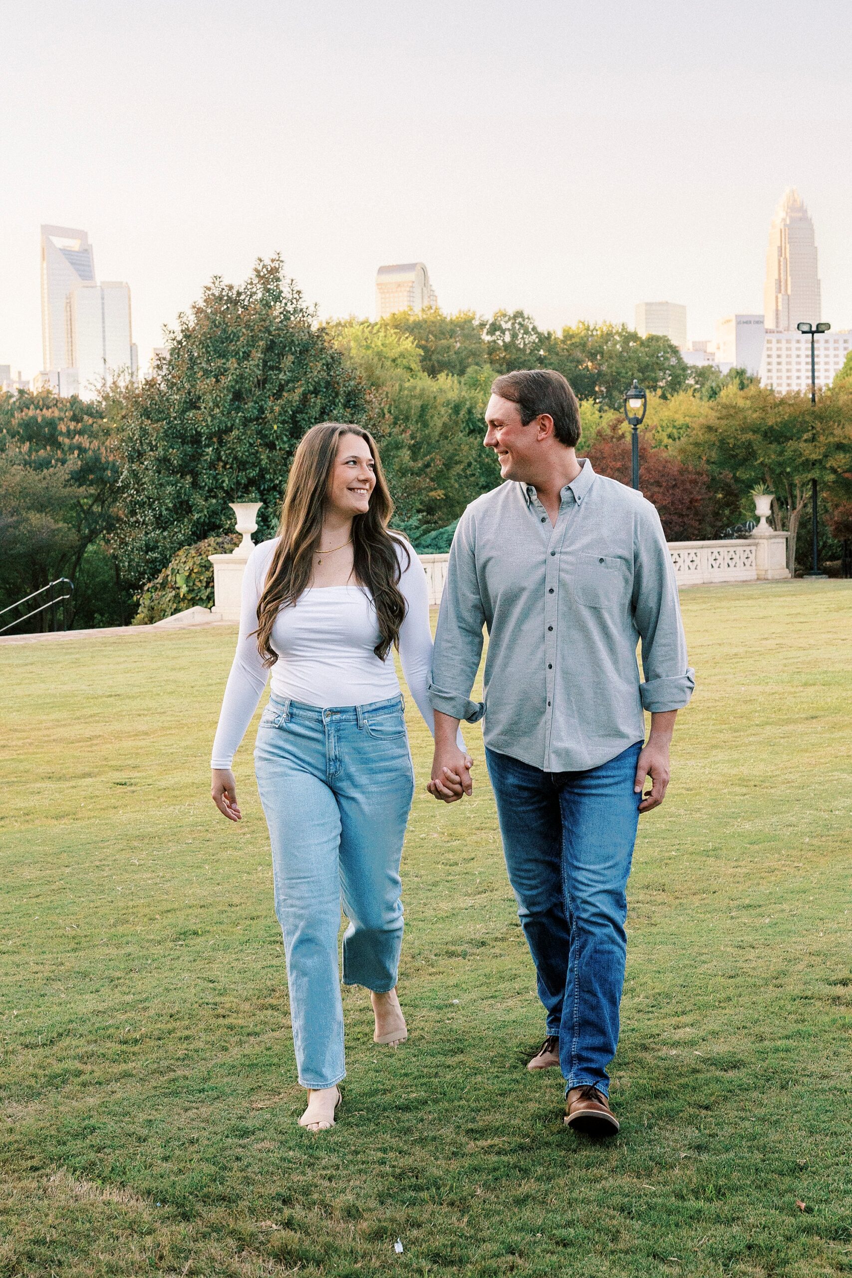 man and woman hold hands walking through Midtown Park