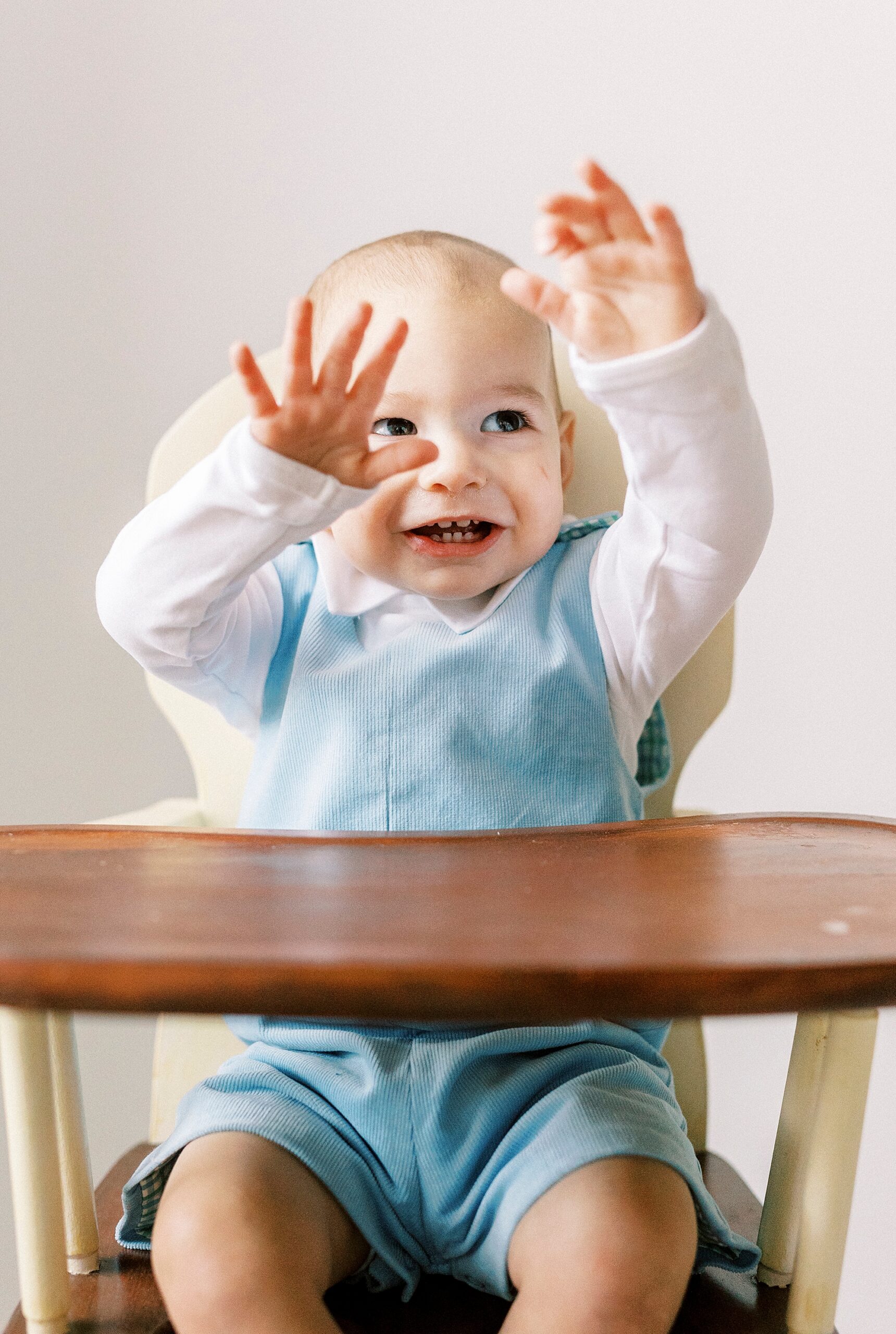 toddler laughs raising hands in the air