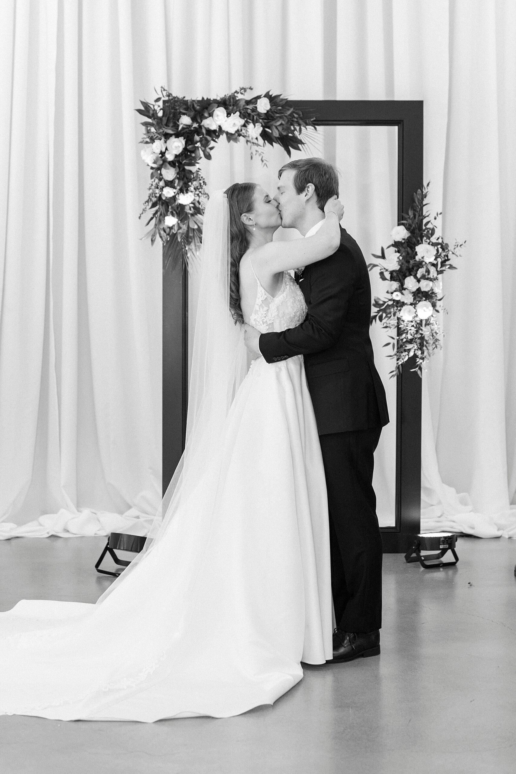 bride and groom kiss during ceremony inside the Mint Museum Uptown