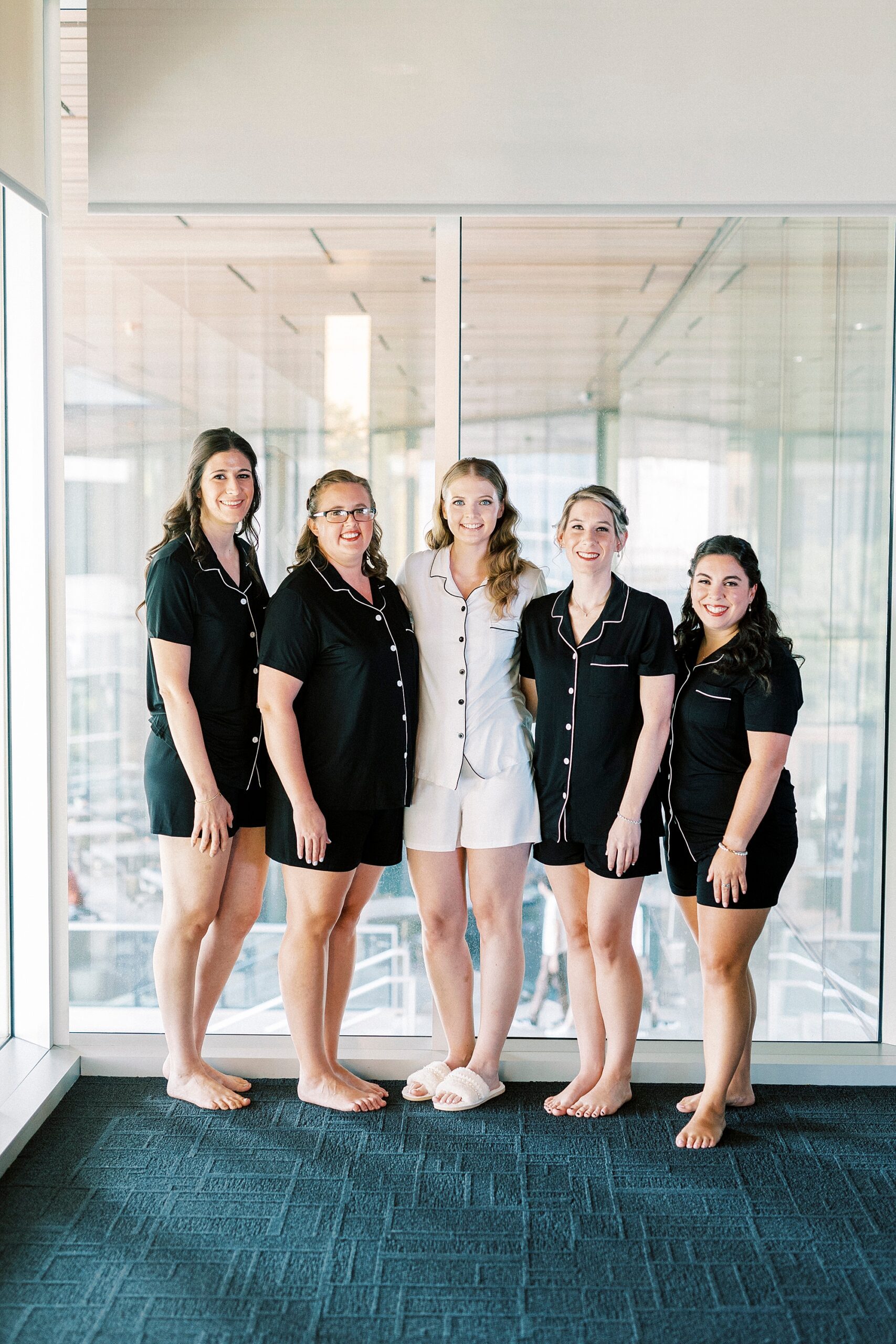 bride poses with bridesmaids in matching black and white pajamas
