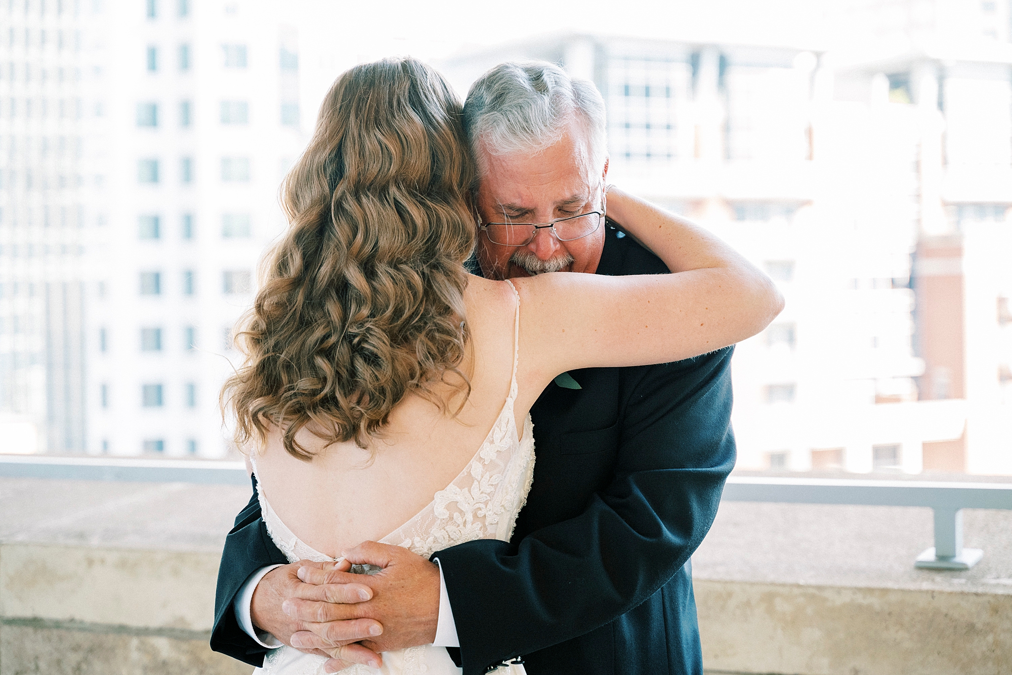 bride and dad hug during first look at the Mint Museum Uptown