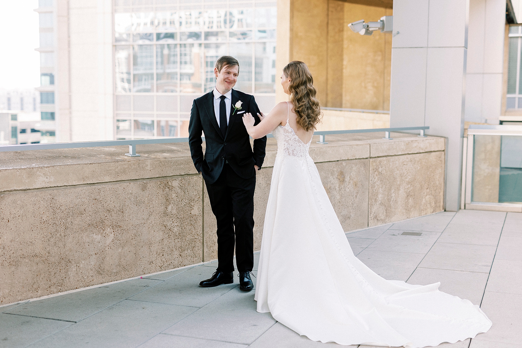 groom turns to look at bride on parking deck at the Mint Museum Uptown