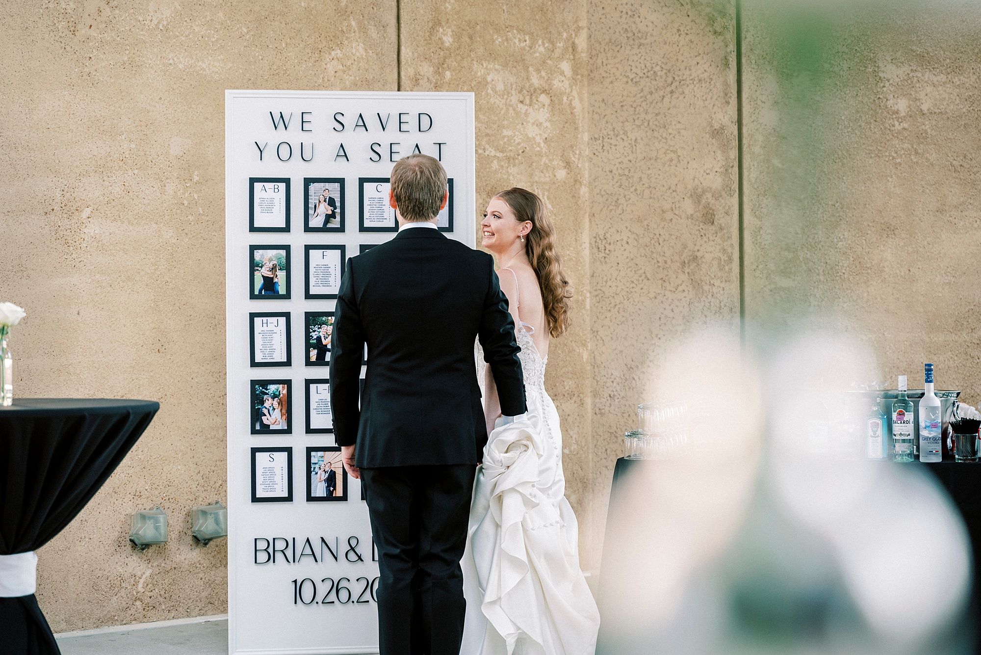 bride and groom pose in front of 3-D printed seating chart at the Mint Museum Uptown