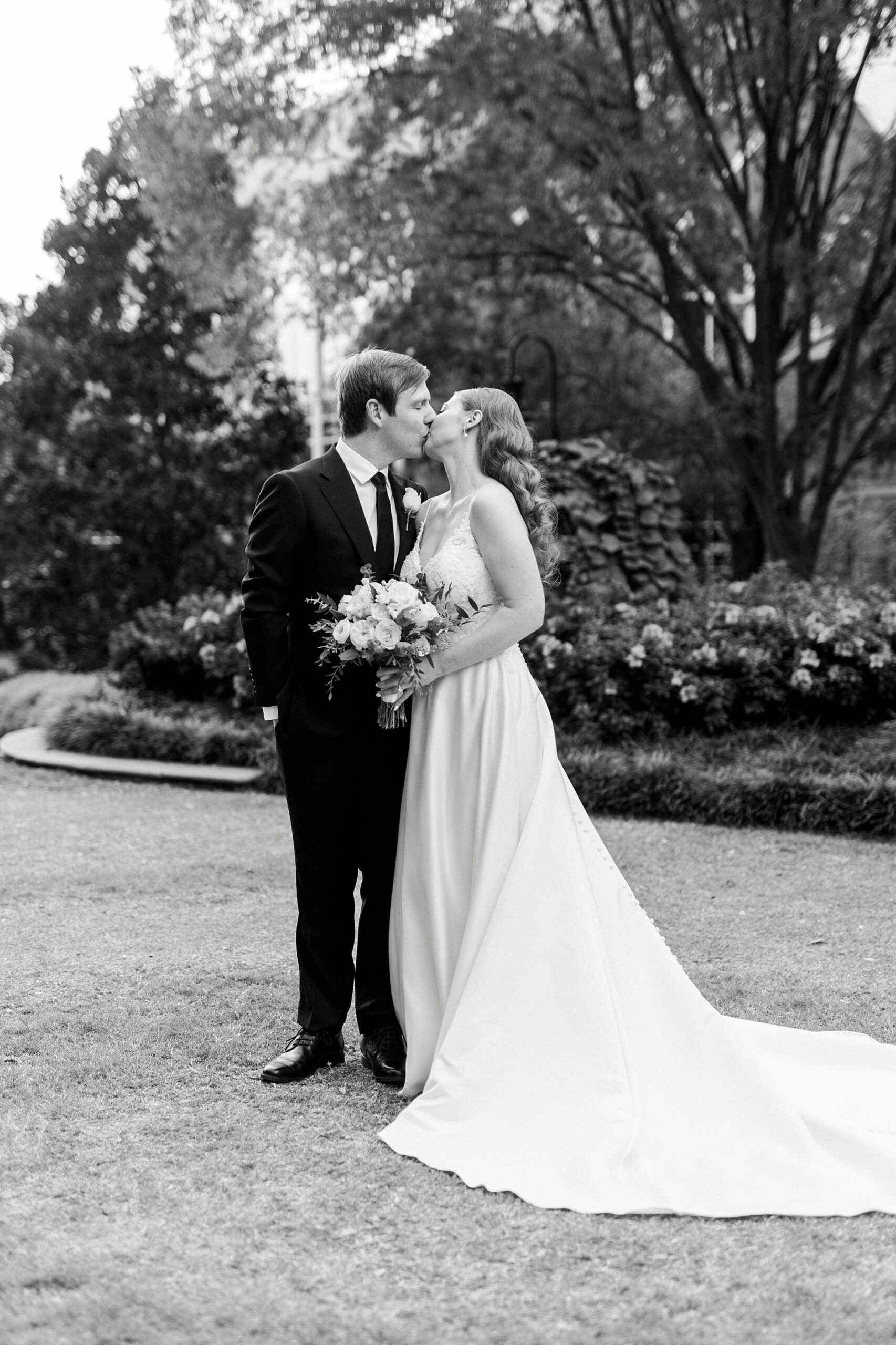 newlyweds kiss in the gardens of the Mint Museum Uptown