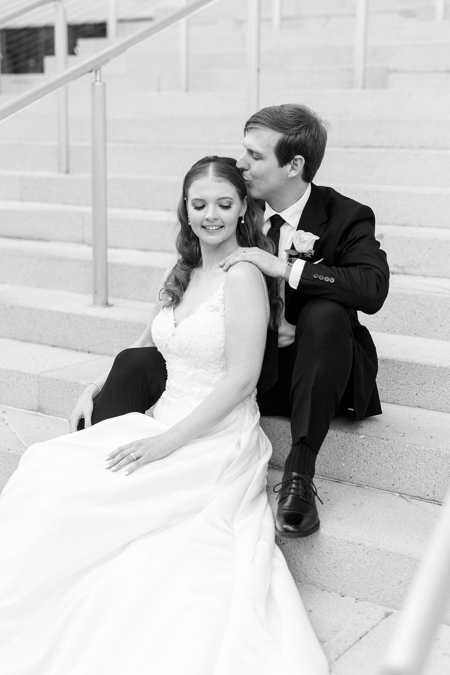 bride and groom sit on steps outside the Mint Museum Uptown