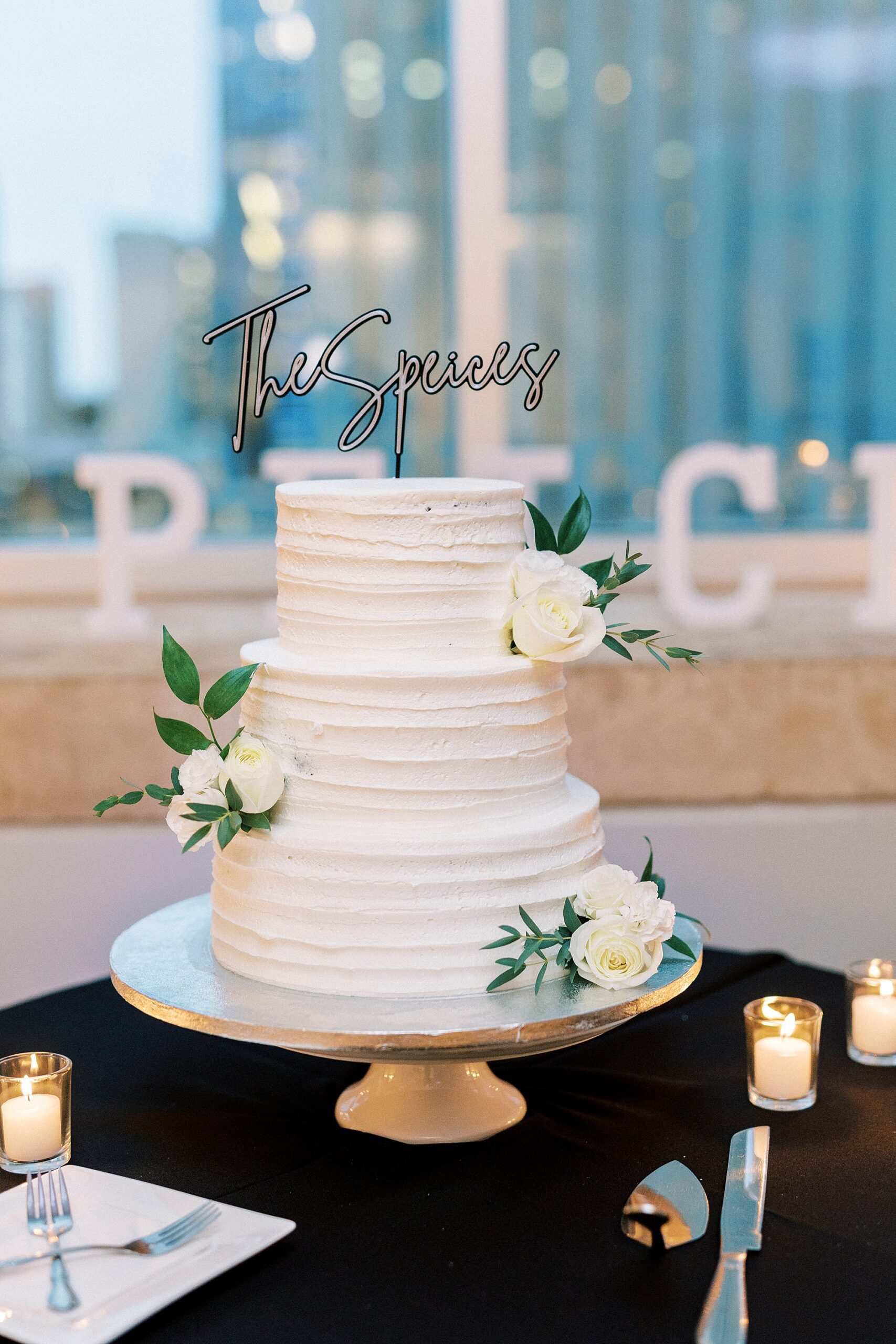 tiered wedding cake with white floral accents inside the Mint Museum Uptown
